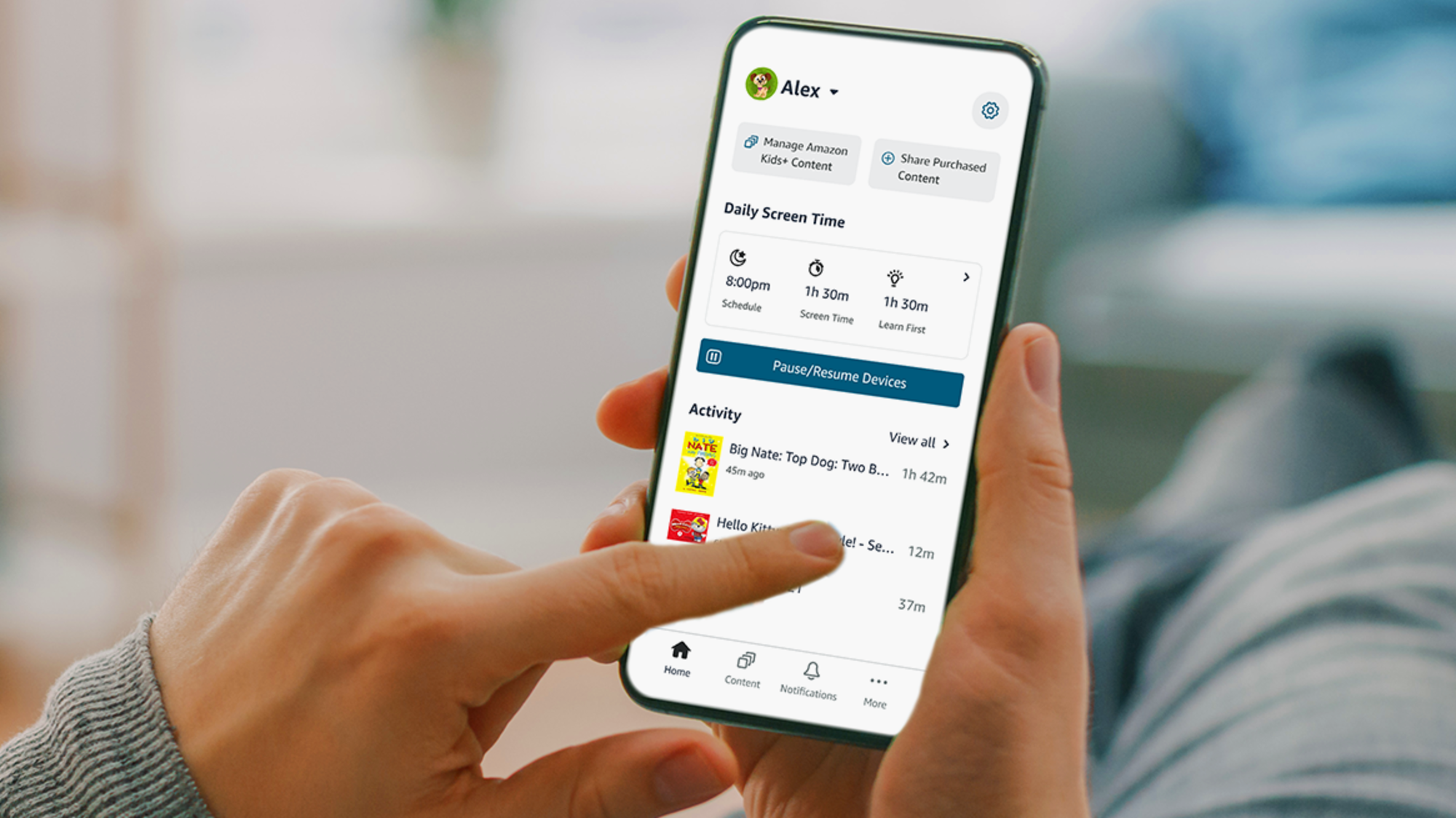 A hand holding a smartphone displaying the Amazon Kids Parent Dashboard interface with colorful icons and controls for managing children's content and screen time.