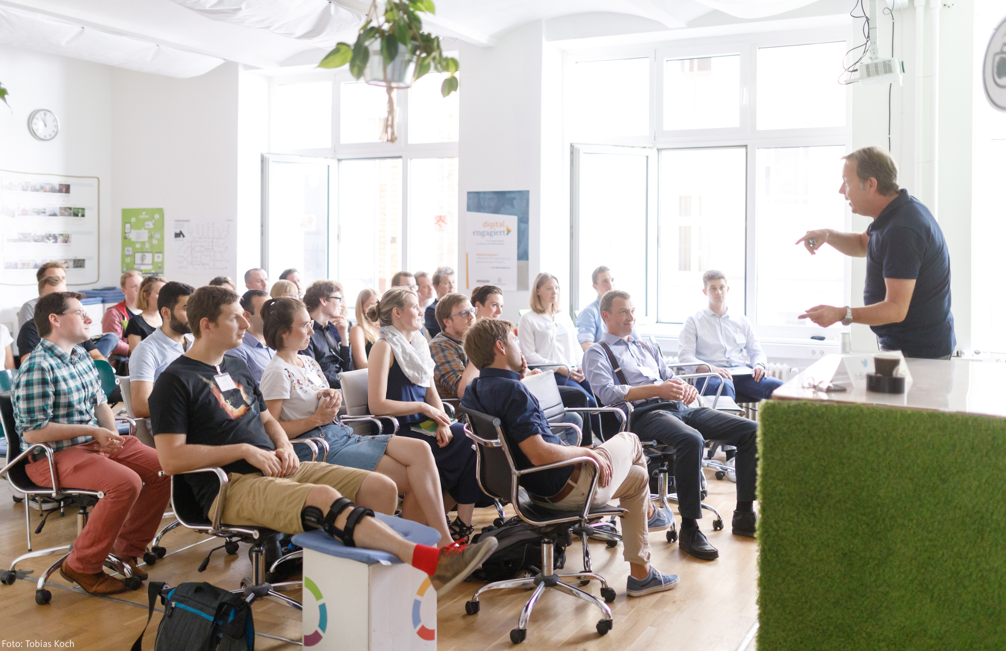 Ralf Kleber steht auf einer kleinen Bühne und hält einen Vortrag zu digital.engagiert.