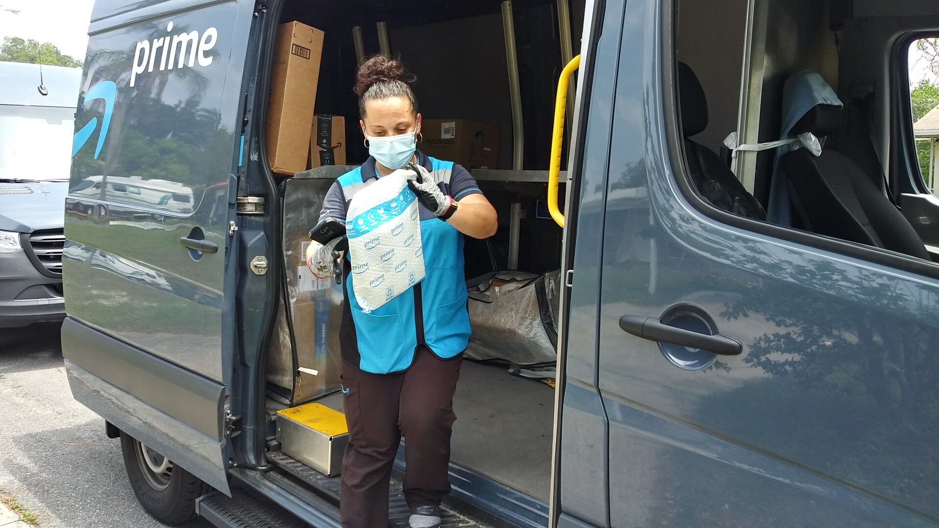 A delivery driver grabs a package from the delivery vehicle. 