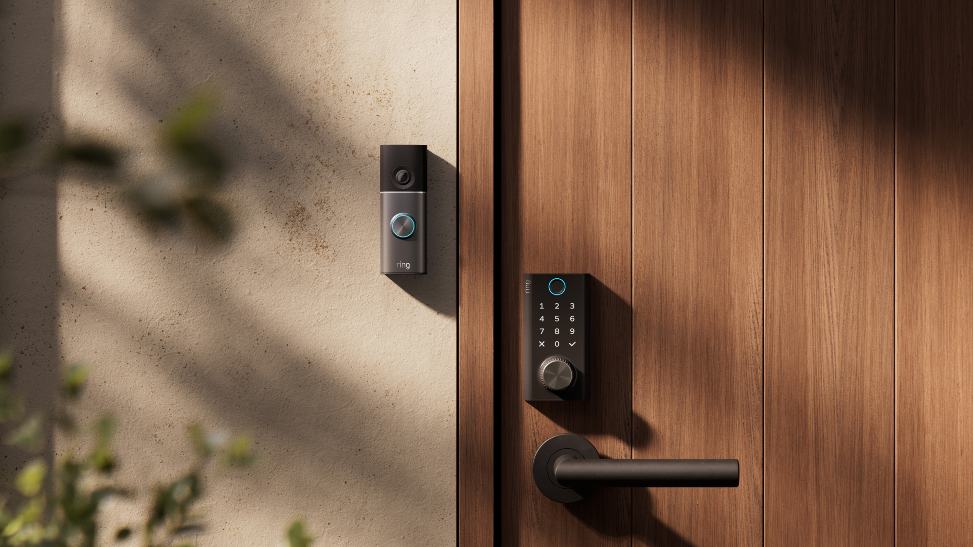 Ring Smart Lock on a door, with a Ring doorbell placed on the wall next to it.