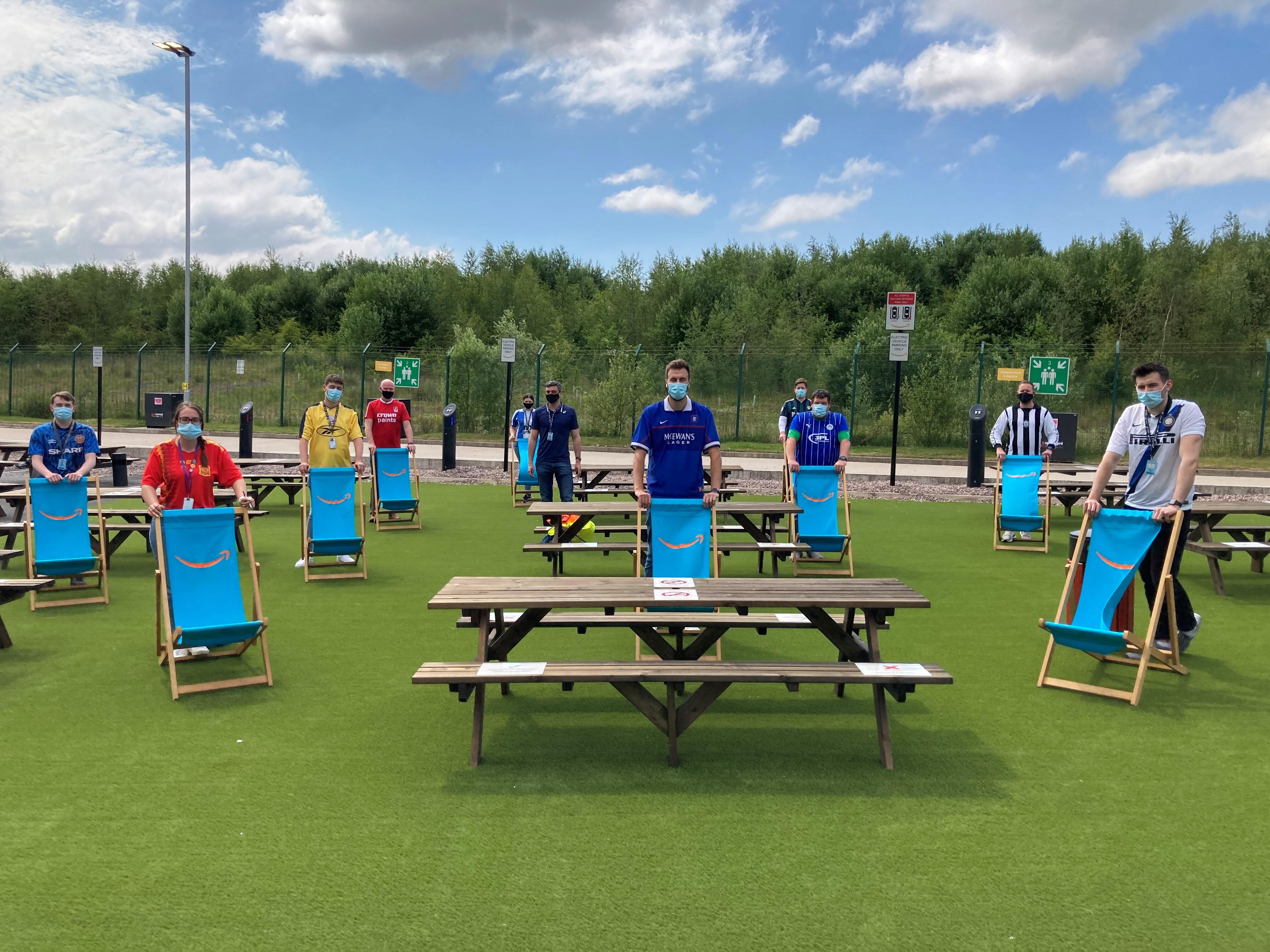 Amazon employees outside the fulfilment centre in Bolton in football shirts socially distanced