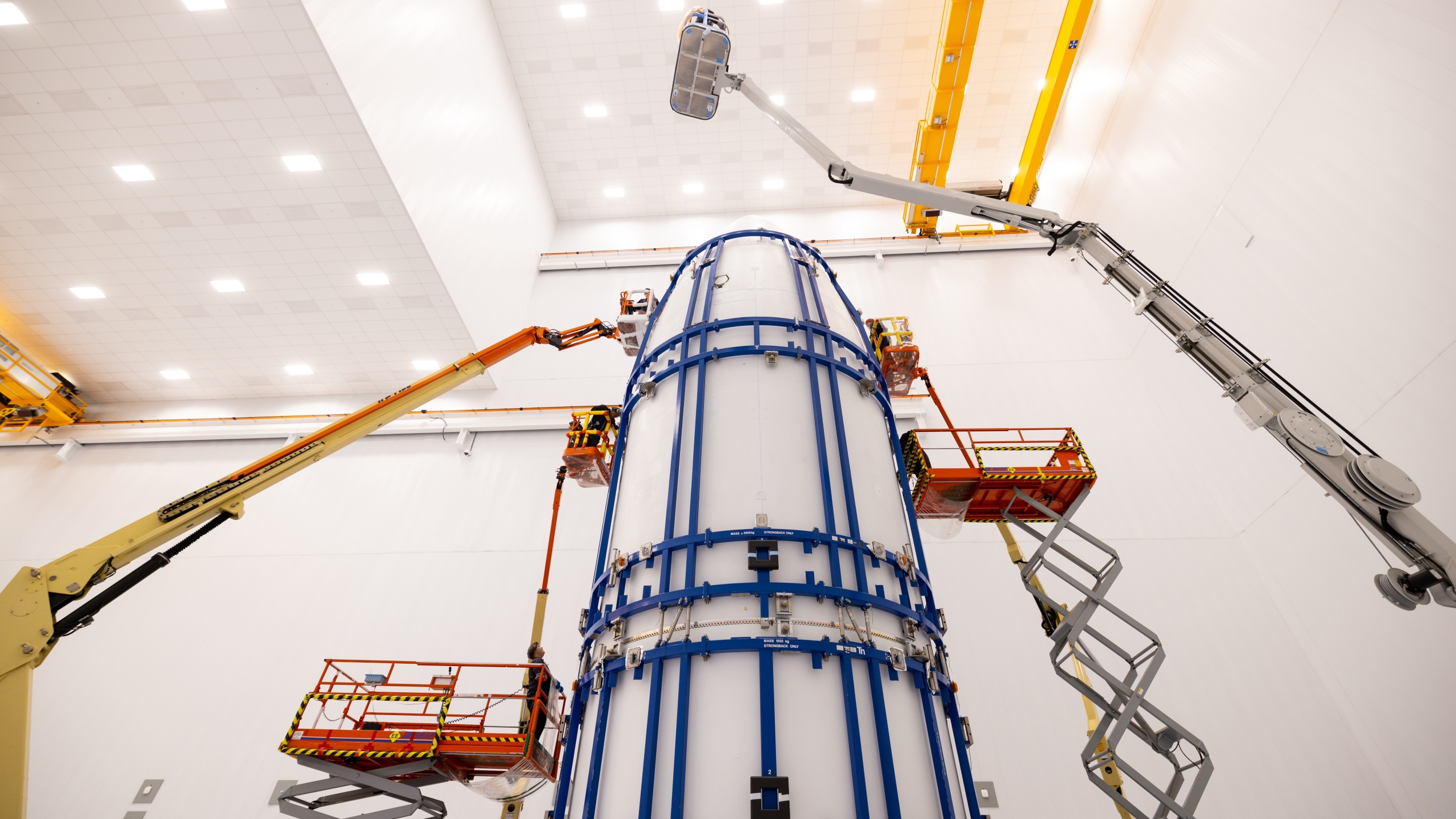 View inside a Project Kuiper facility showing a spacecraft and cranes