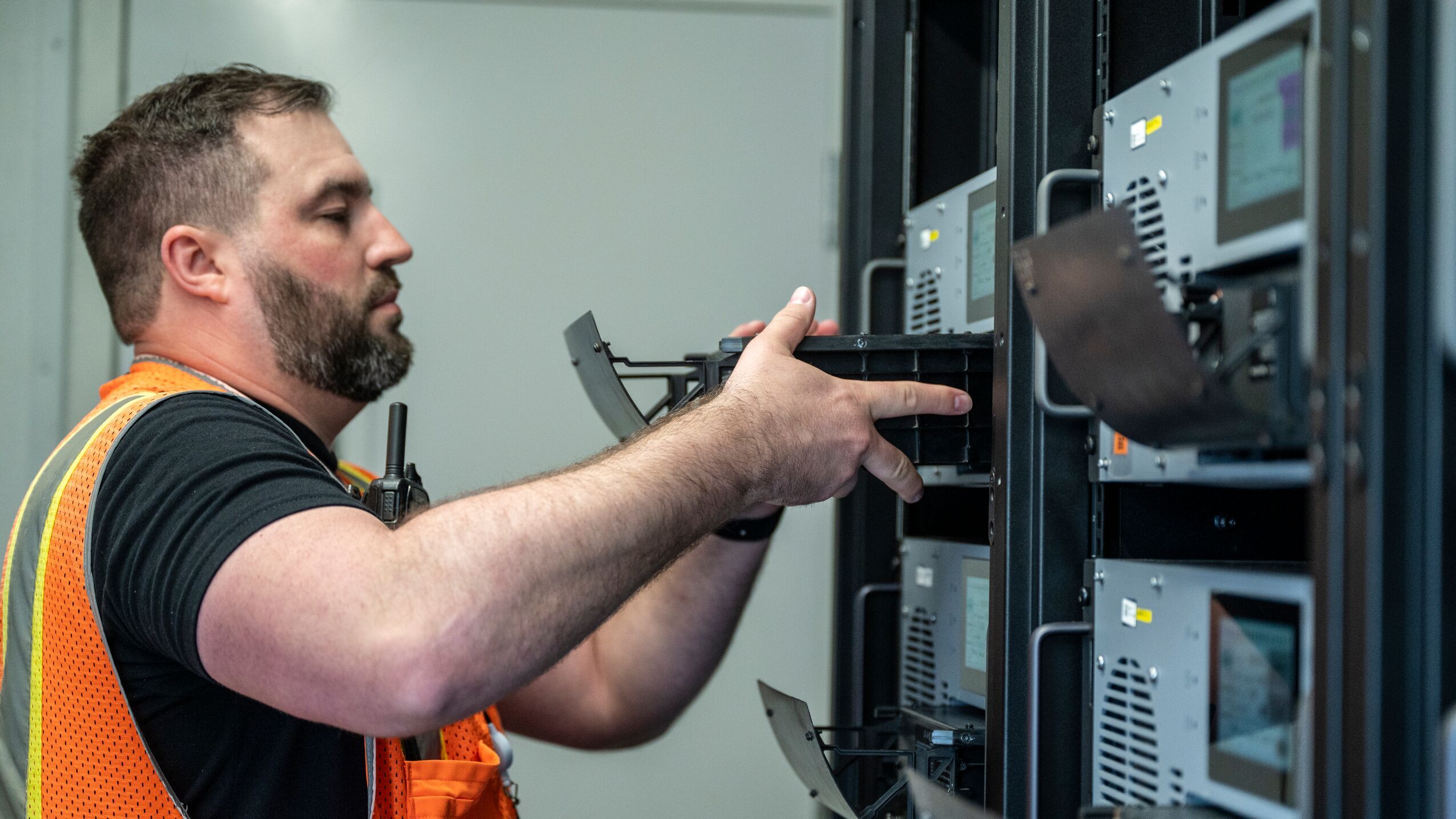 An image of an employee pulling a battery from a wall of batteries.