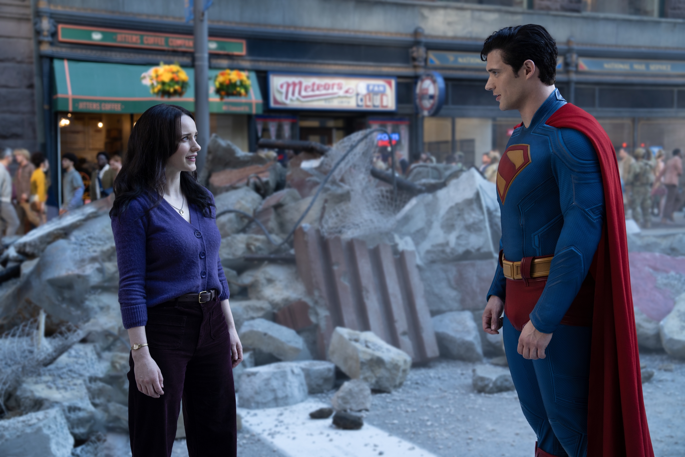 Superman talking to a woman amid city rubble