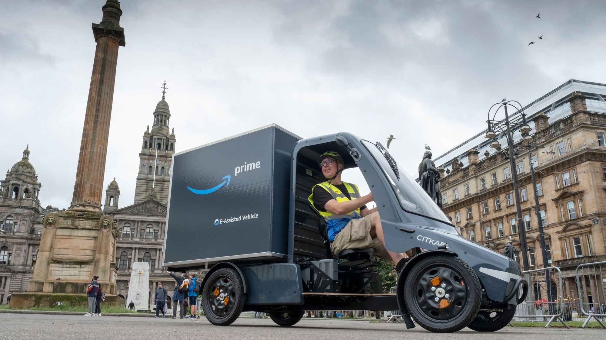 Amazon Prime electric delivery vehicle in front of Glasgow's George Square