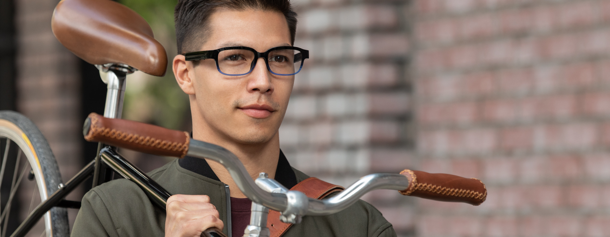 An image of a man wearing his Echo Frames glasses while walking down a sidewalk carrying his bike.