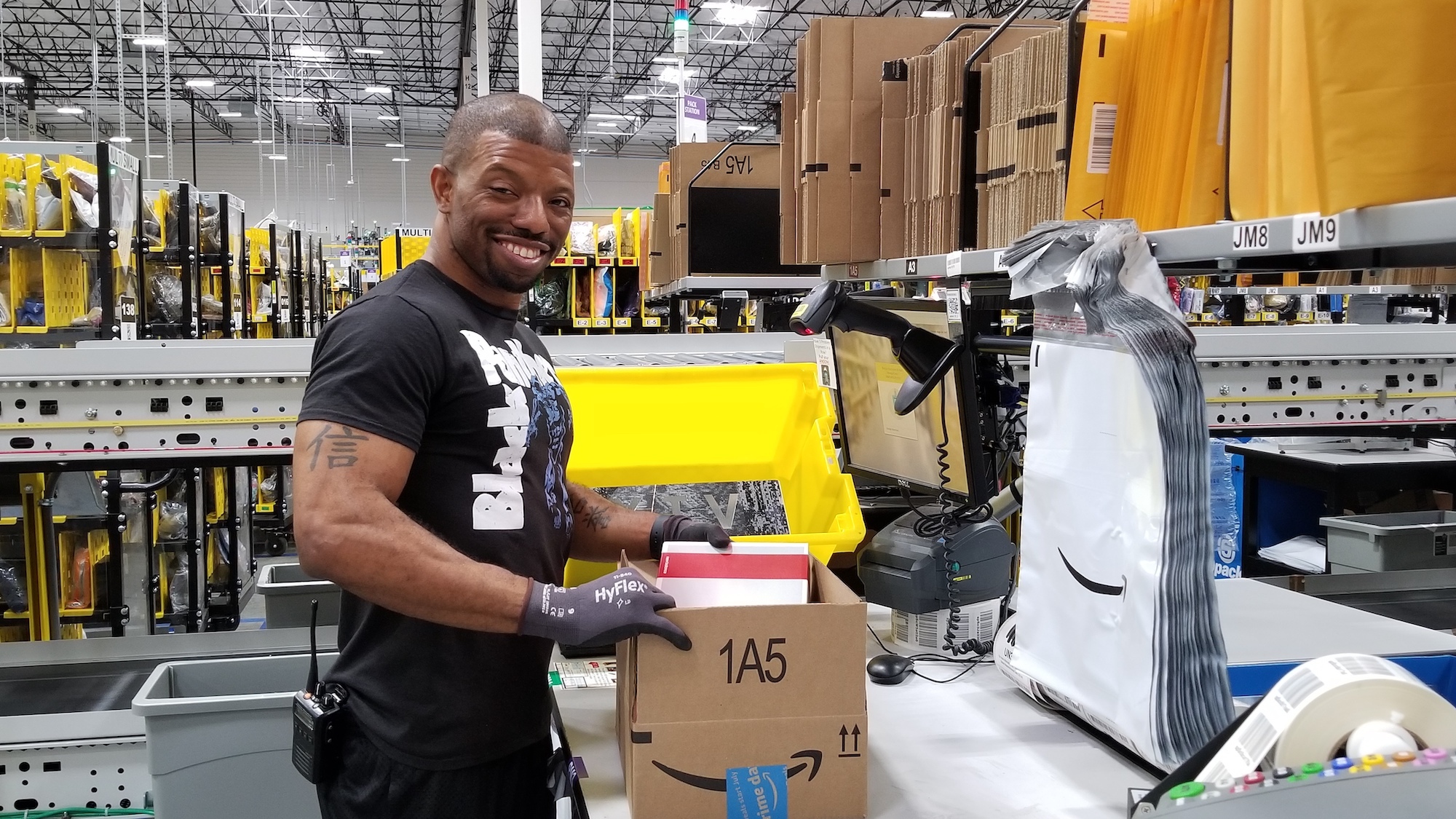 Amazon fulfillment center employee at a packing station