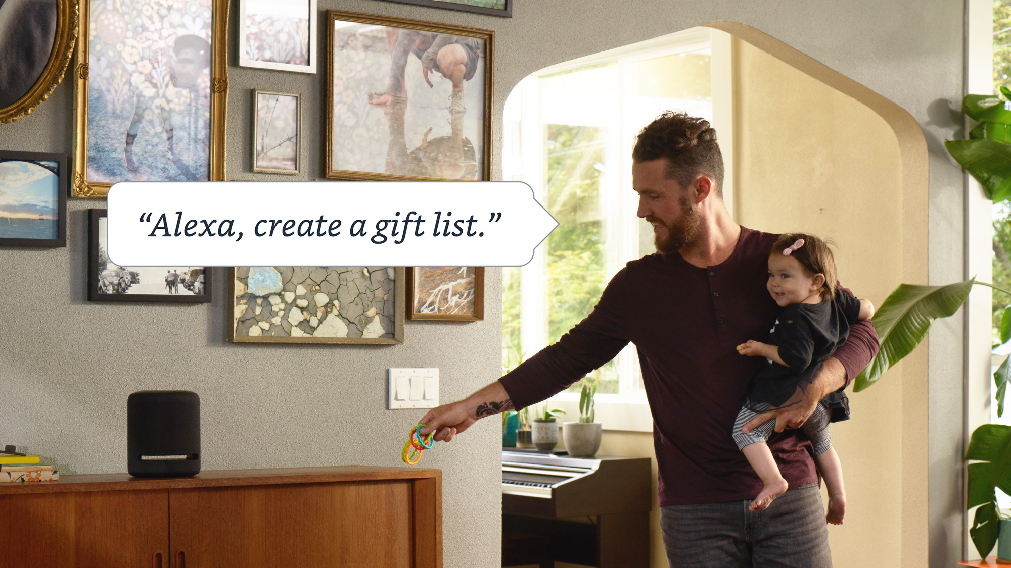 A man holding a toddler asking his Alexa device to create a gift list.