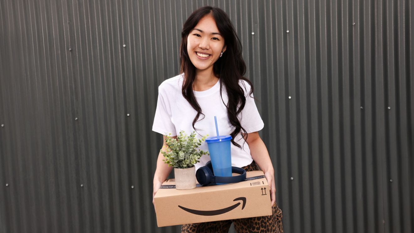 A woman holds an Amazon delivery box