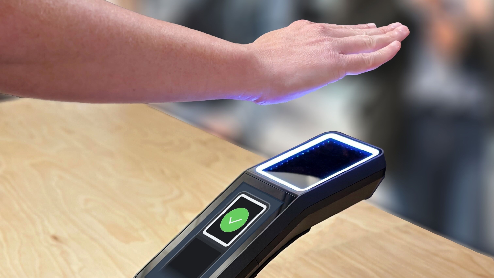 Hand over Amazon One palm scanning device on wooden surface