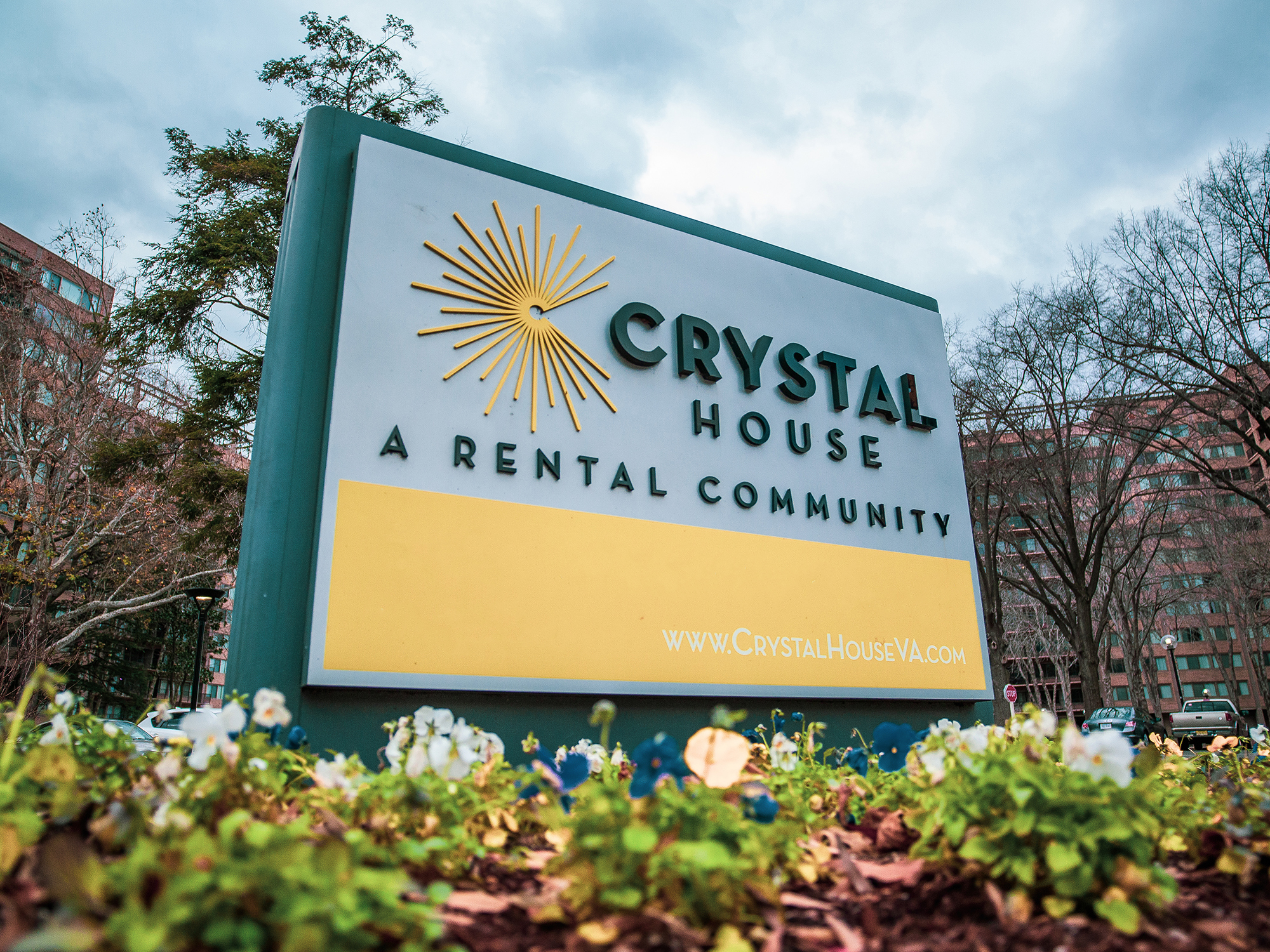 An image of a sign in front of a building that reads "Crystal House: A rental community" with the building's website (www.crystalhouseva.com) at the bottom.