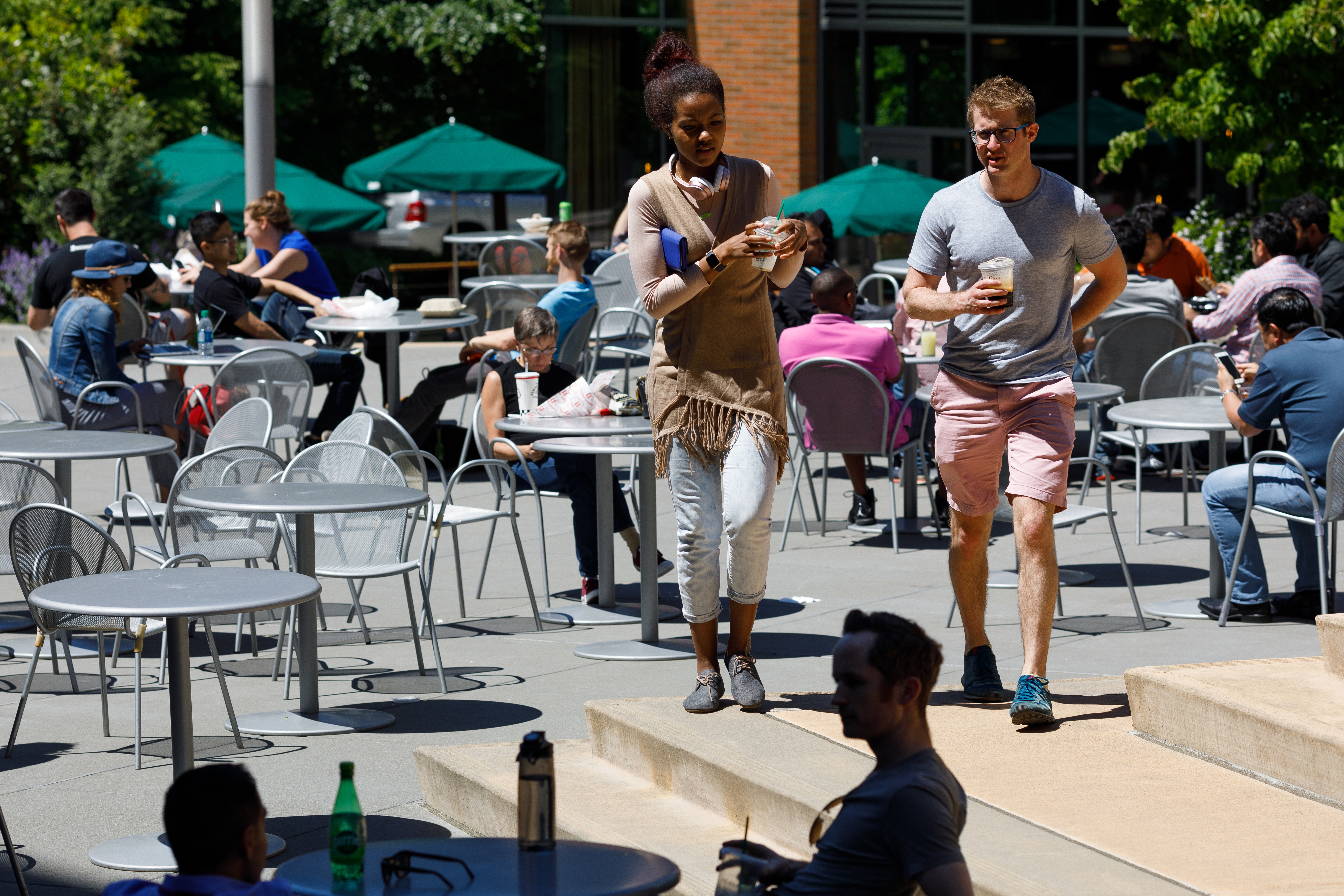 Amazon employees walk, talk, drink, and eat outside on Amazon's Seattle campus. 