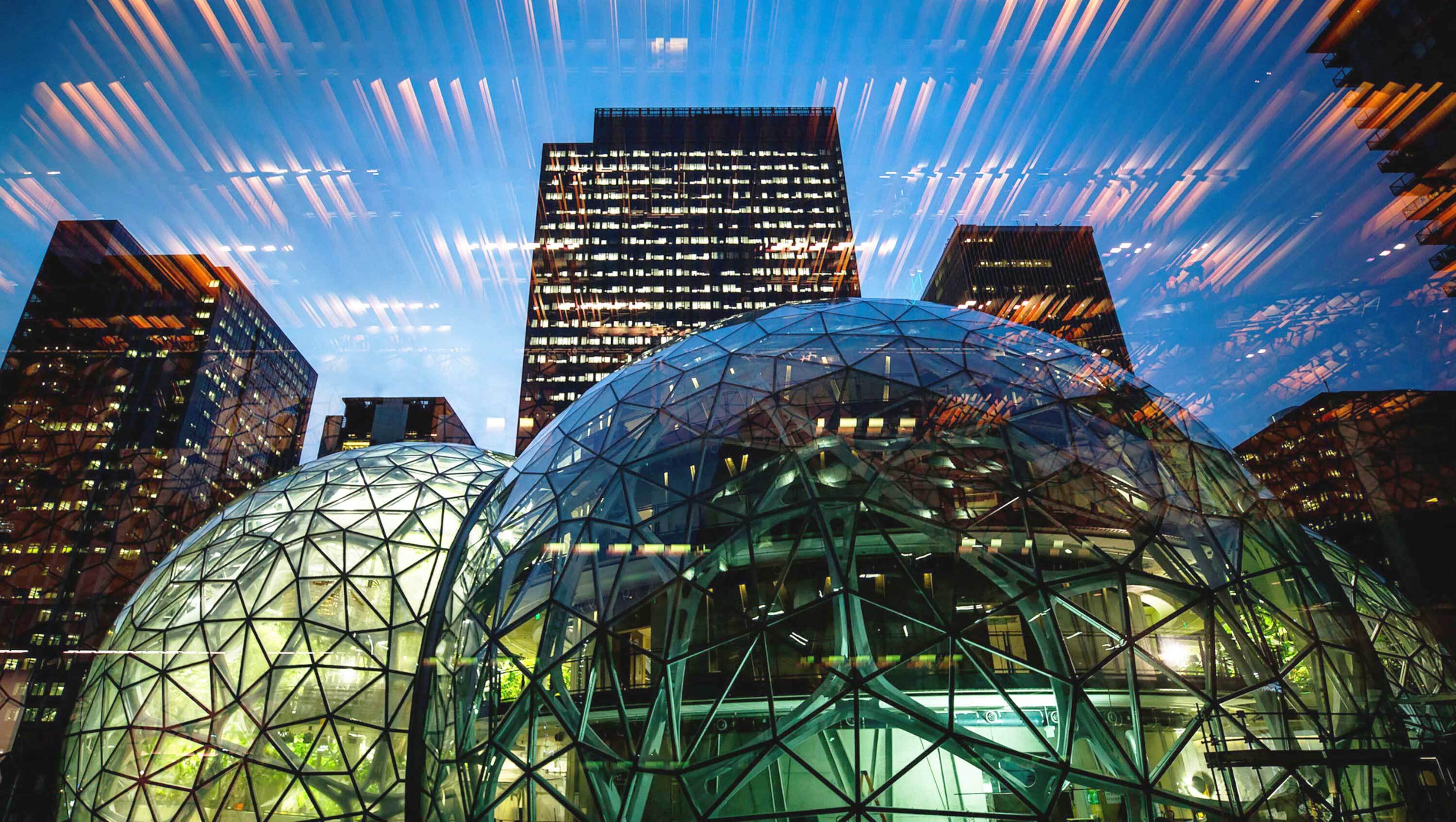 The Spheres illuminated at night with city buildings in the background.