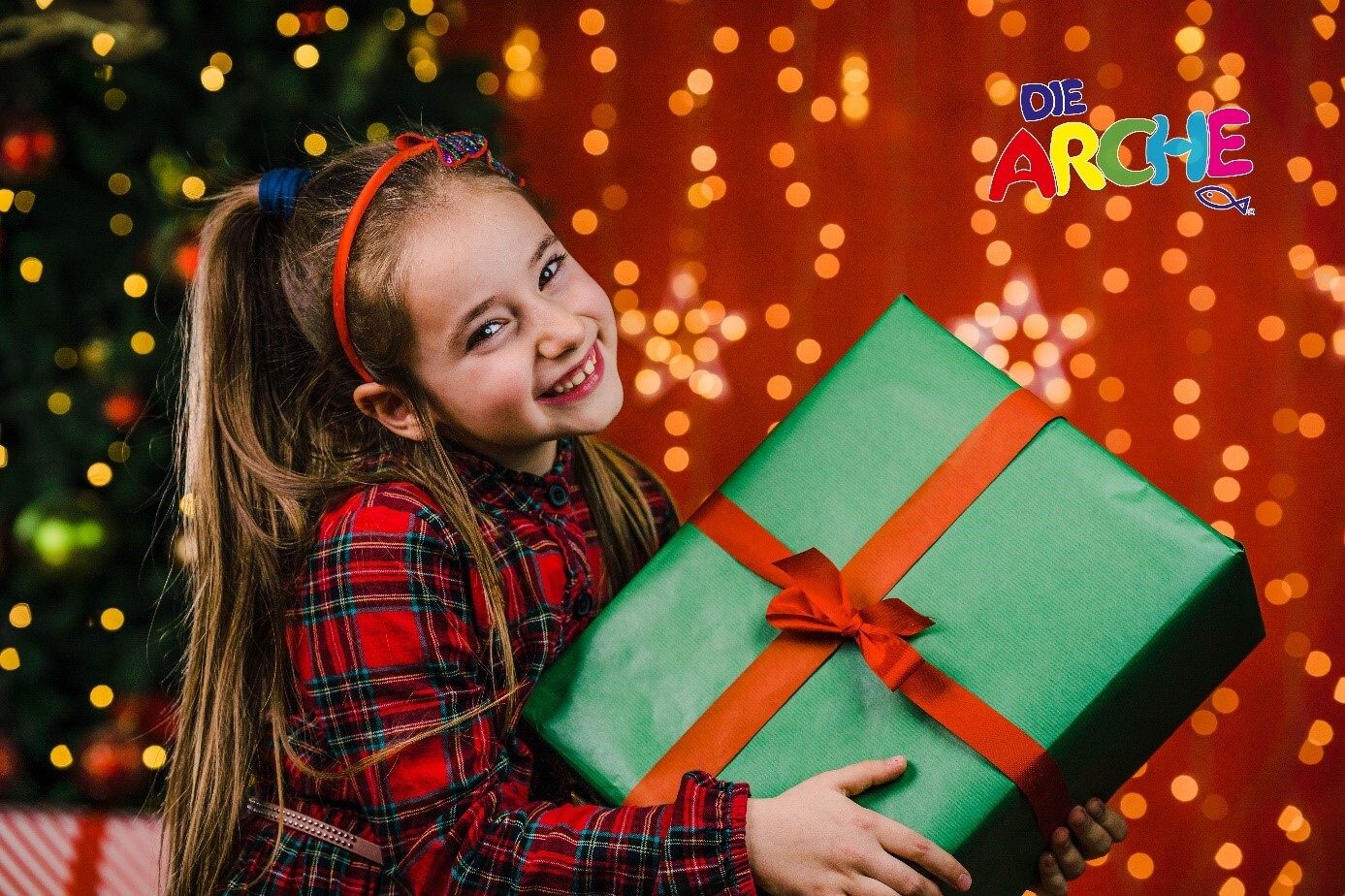 kleines Mädchen mit Weihnachtsgeschenk
