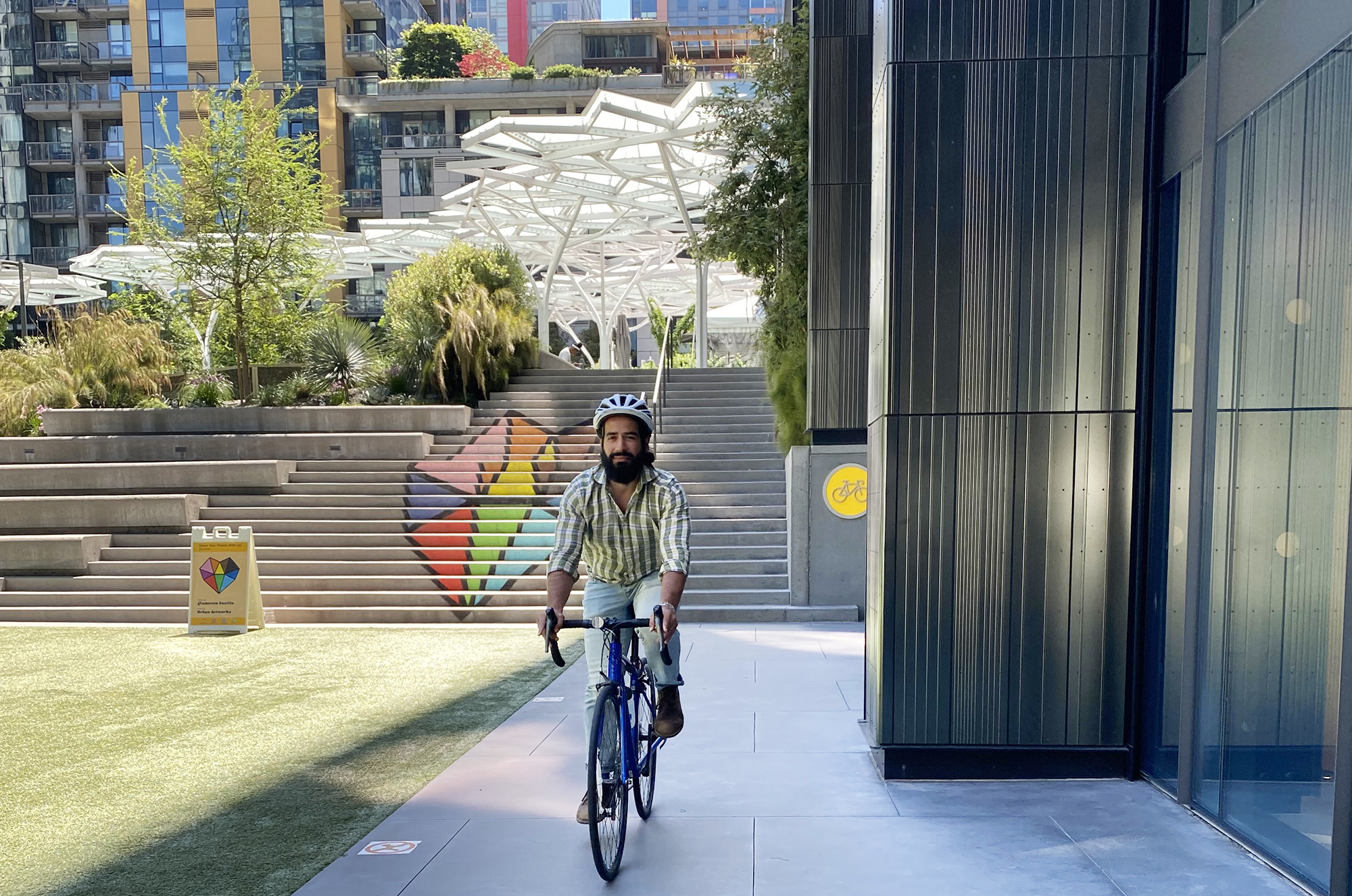 A man rides a bike wearing a helmet through the Amazon HQ in Seattle.