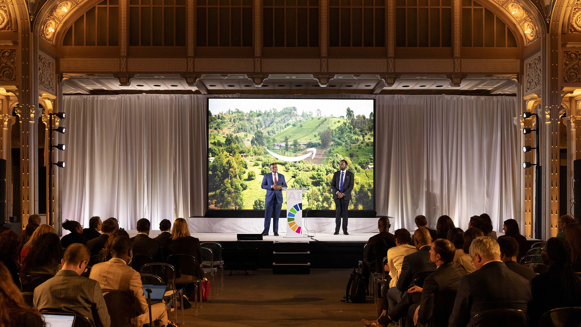 A photo of AWS Vice President Swami Sivasubramanian and Dr. Kingsley Ndoh, founder of Hurone AI, speaking on stage at an UN summit on generative AI.