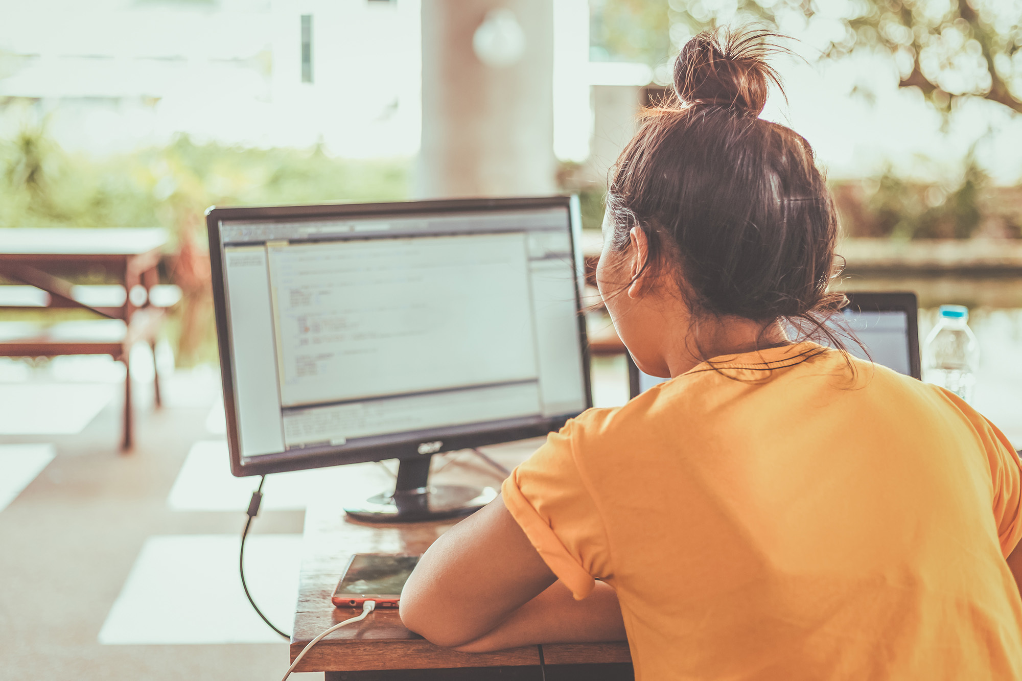 This image shows a woman coding on her computer.