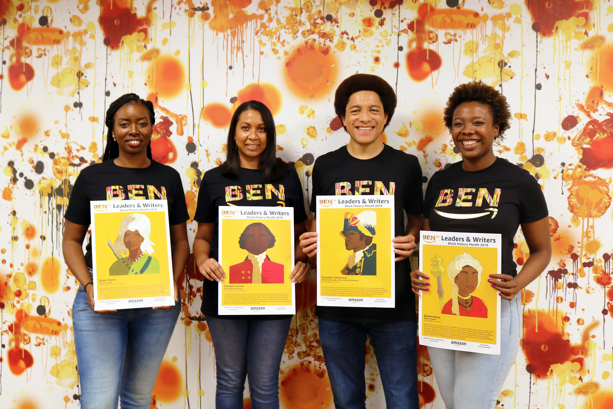 Picture of Amazon's Black Employee Network members holding posters of historic black figures (from left to right, Ramat Tejani with poster of Queen Nanny, Rebecca Wijeyesinghe with poster of Olaudah Equiano, Frederic Houinato with poster of Toussaint L‘Ouverture and Aisha Suleiman with poster of Queen Amina)