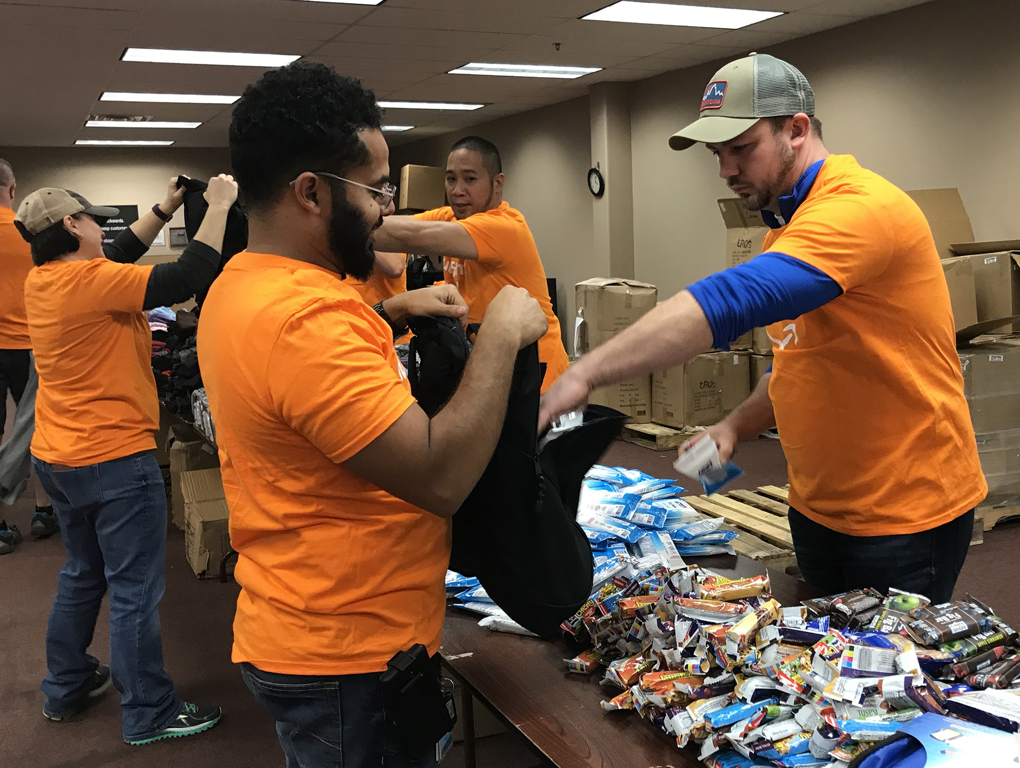 Amazon associates filling backpacks with essential items 