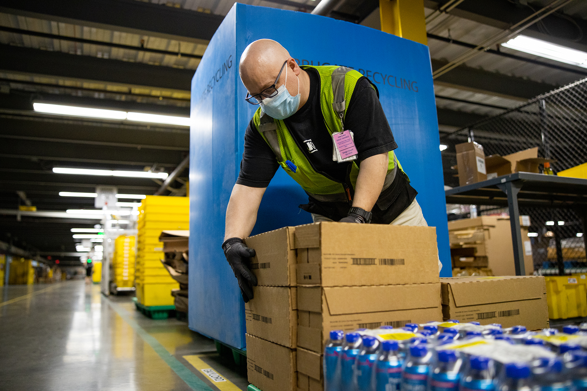 Amazon associate packs or unpacks boxes in a fulfillment center