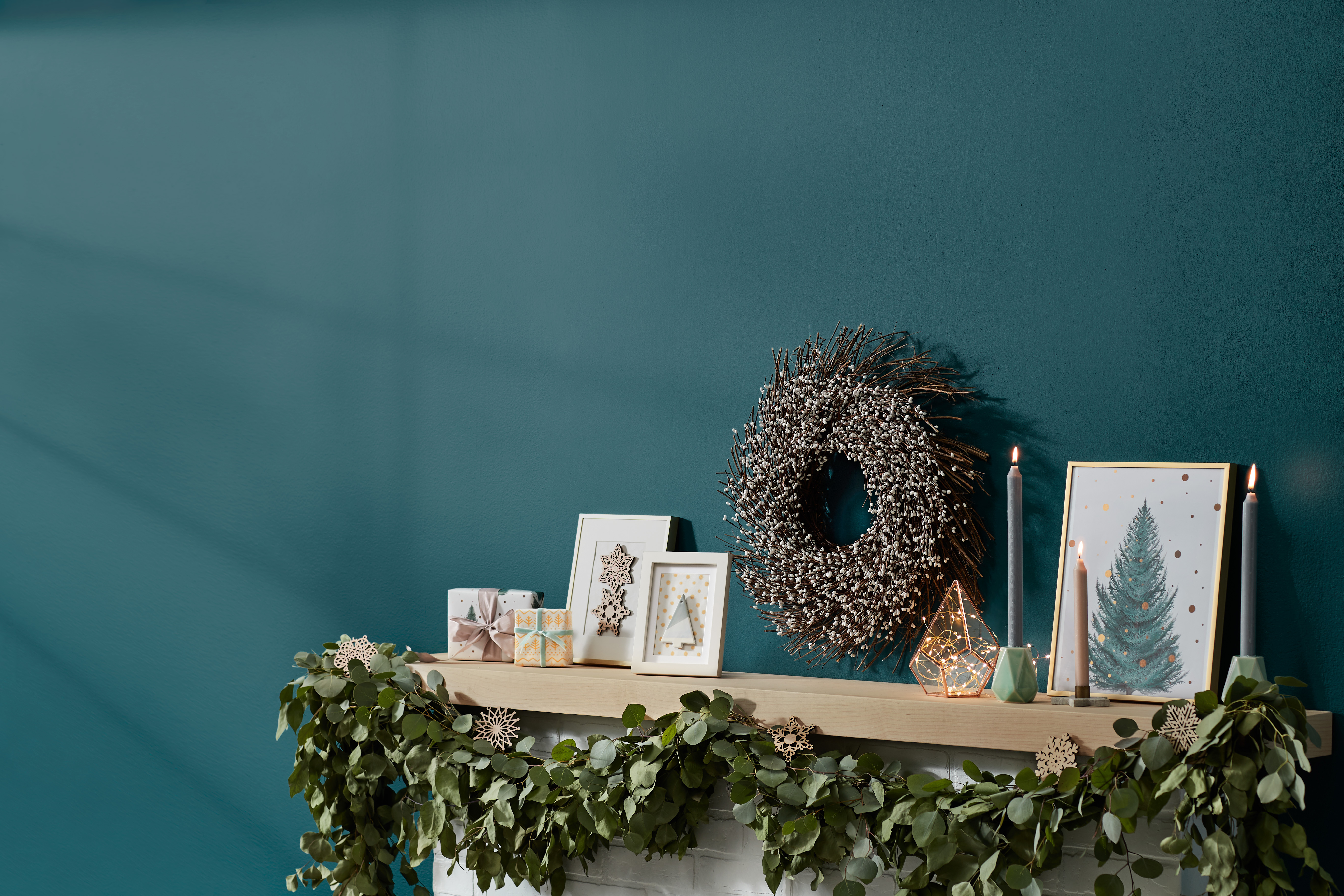 Weihnachtsgeschenke und Weihnachtsdeko stehen auf dem Kaminsims.