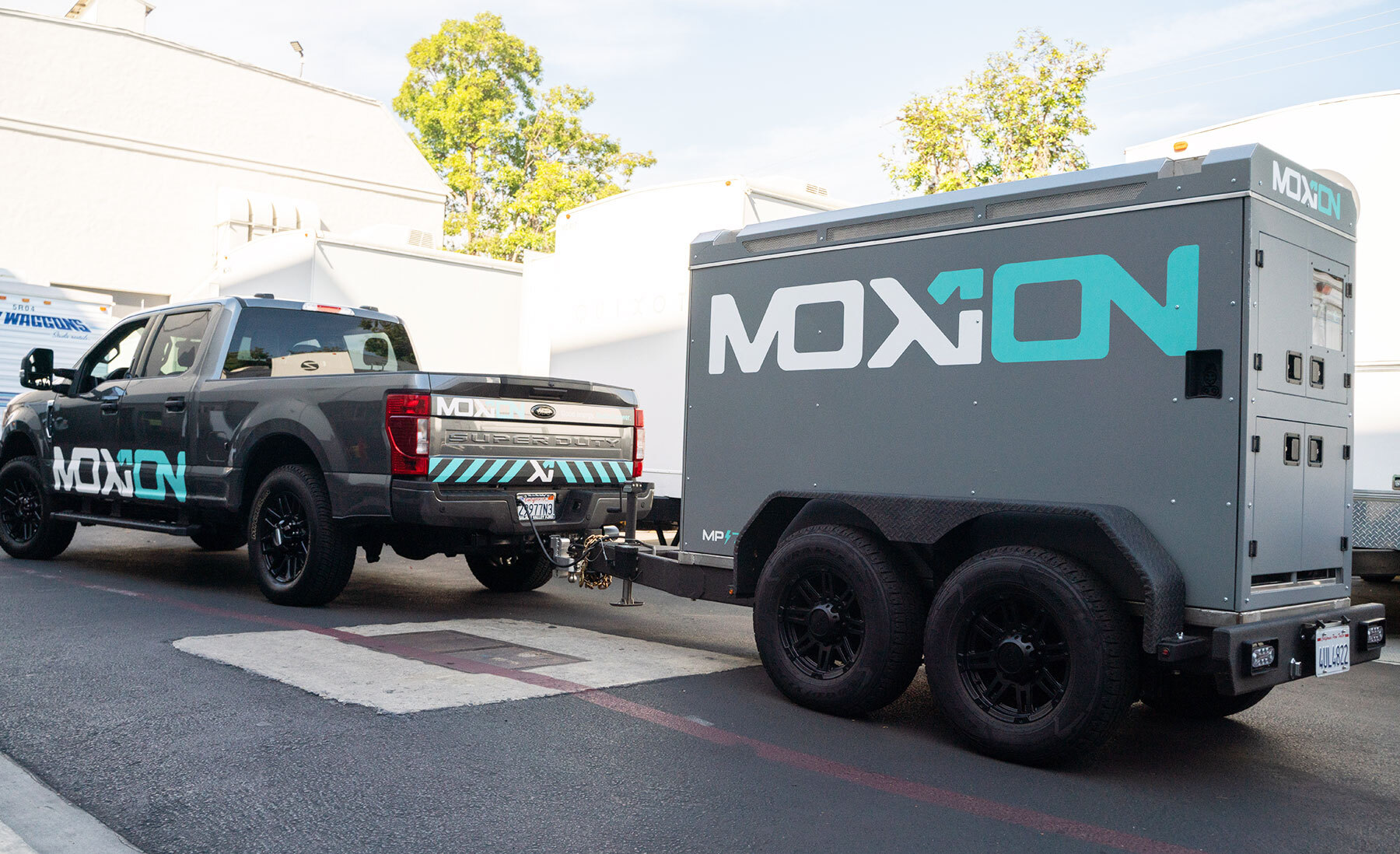 Moxion truck towing a mobile battery trailer through a studio backlot