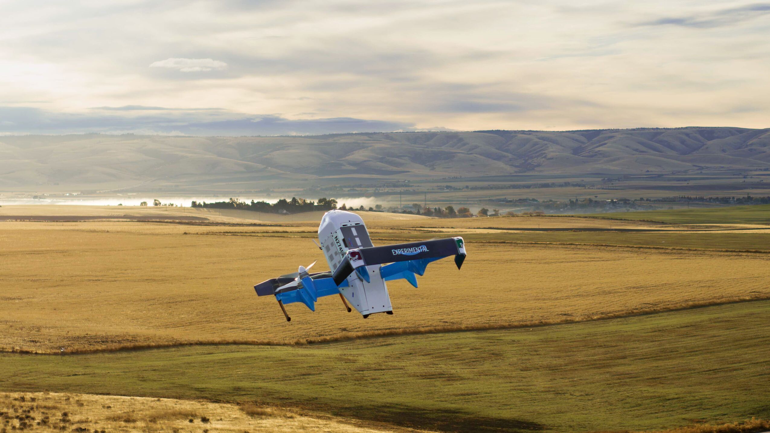 Amazon Prime Air drone flying over rural landscape