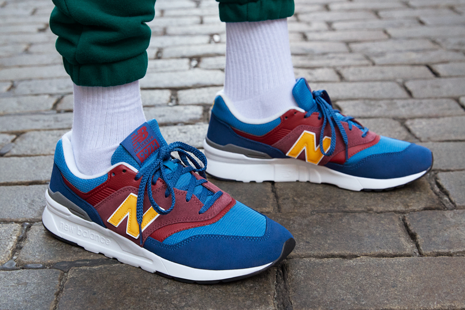 An image of someone's shoes. They are wearing colorful New Balance shoes.