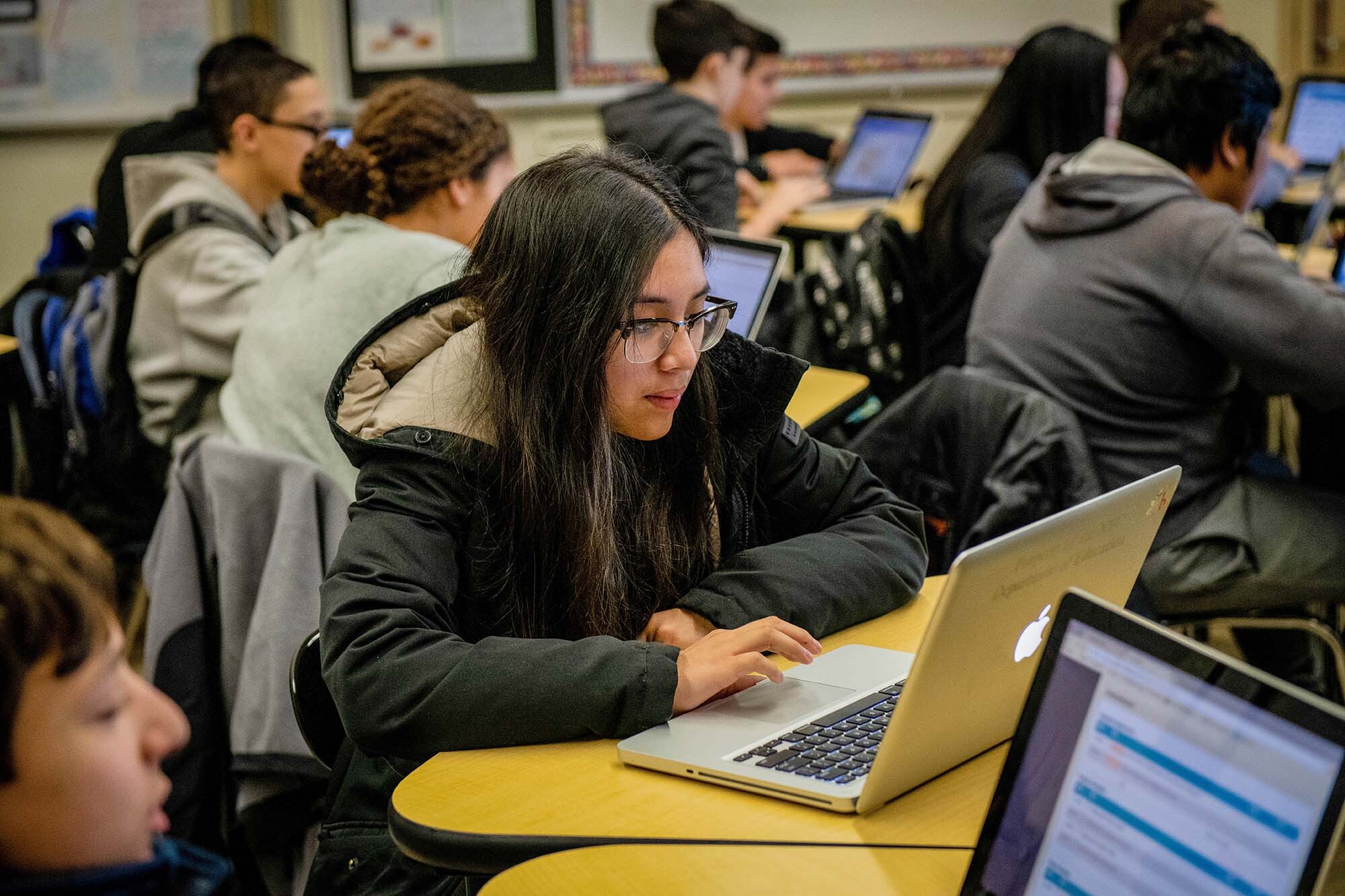 Students work on coding programs on laptop computers in a classroom at a New York City school. 