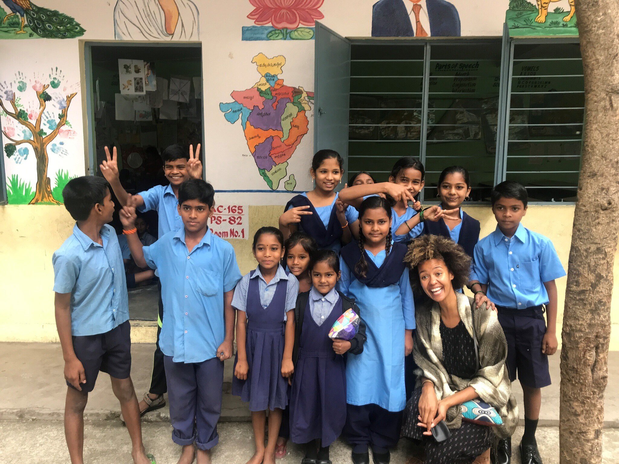 A group of 12 schoolchildren in Bangalore, India pose with an Amazon employee
