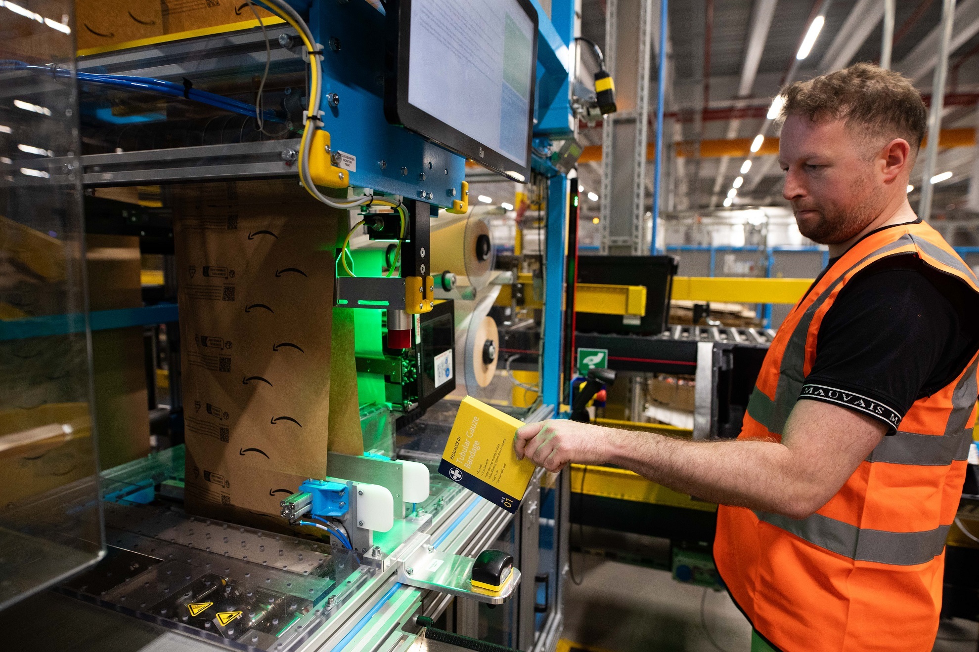 Umweltfreundlichere Verpackung bei Amazon: Foto der Maschine und einem Mitarbeiter, der mit der Maschine arbeitet.