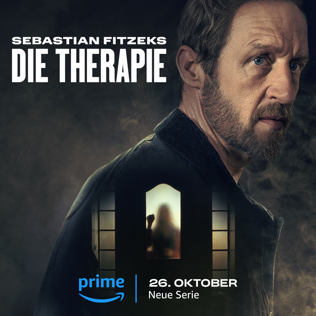 Aufmacher der neuen Prime Video Serie Die Therapie nach dem Buch von Sebastian Fitzek. Das Bild zeigt den Hauptdarsteller seitlich und den mysteriösen Umriss einer verglasten Haustür, hinter der der eine Frau erkennbar ist.