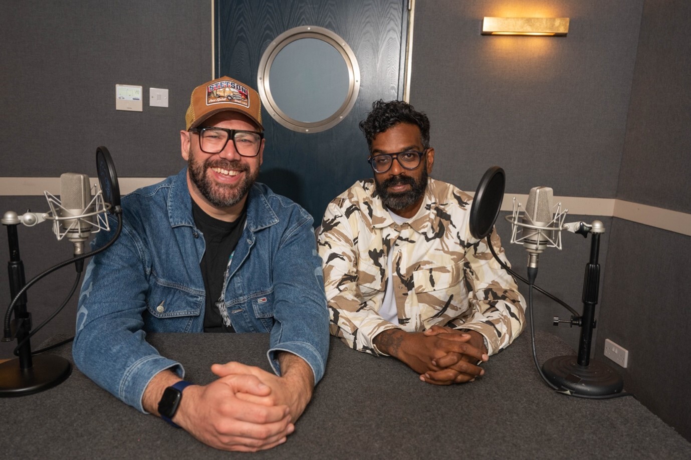Comedians Romesh Ranganathan and Tom Davies in a podcast studio