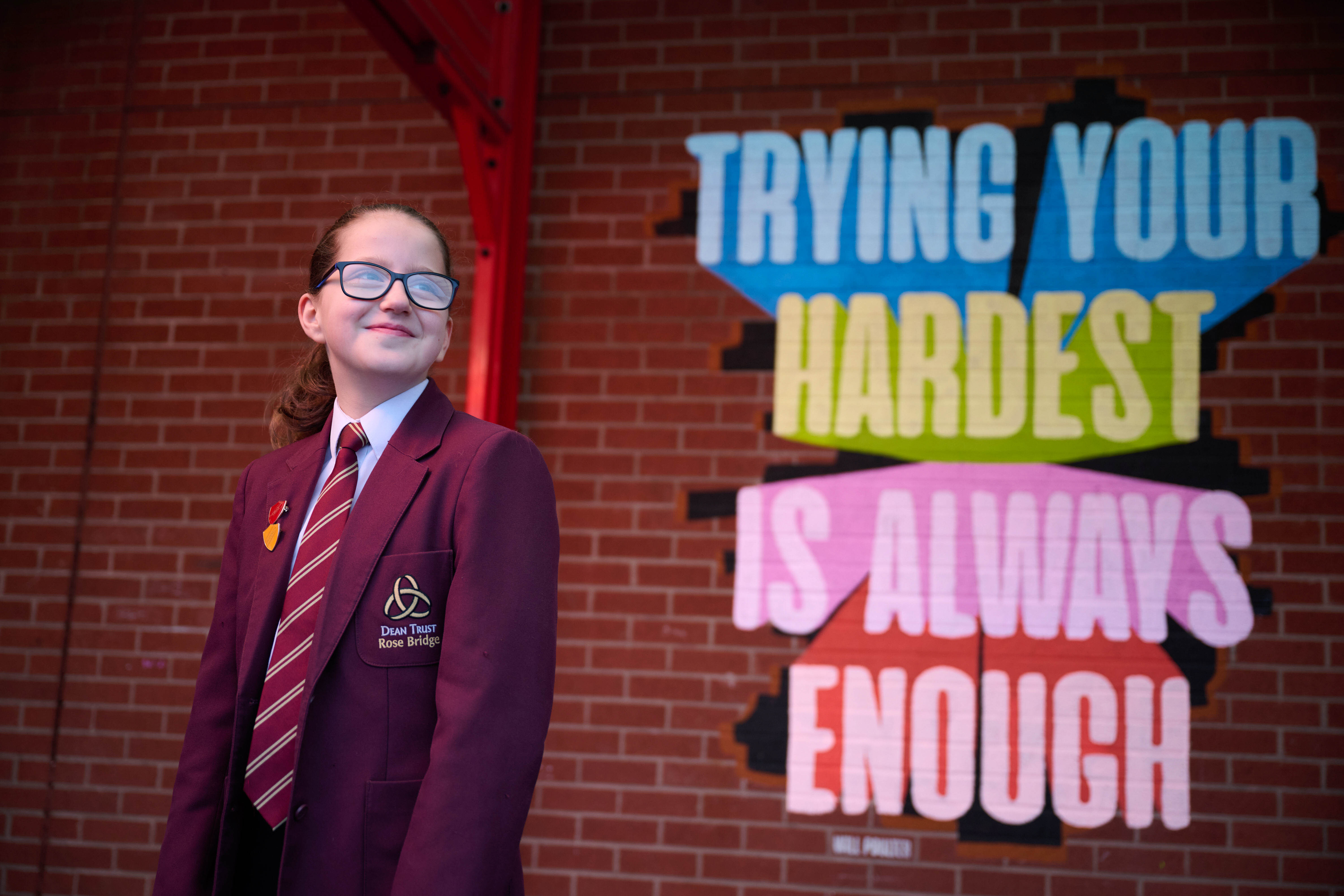 A student stands in front of a Will Poulter quote