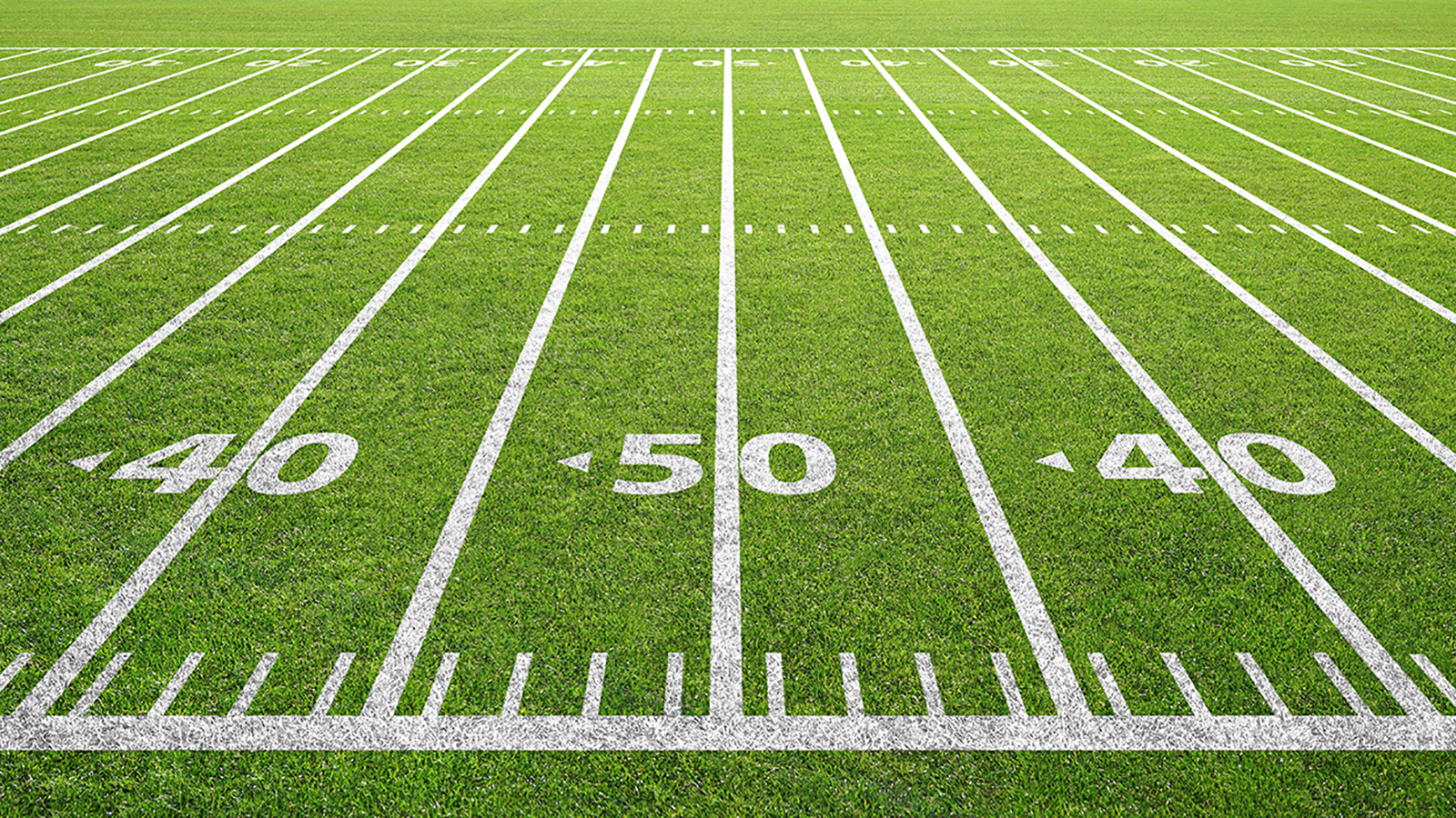 A sideline angle of yard lines are painted on a football field, centered on the 50-yard line.