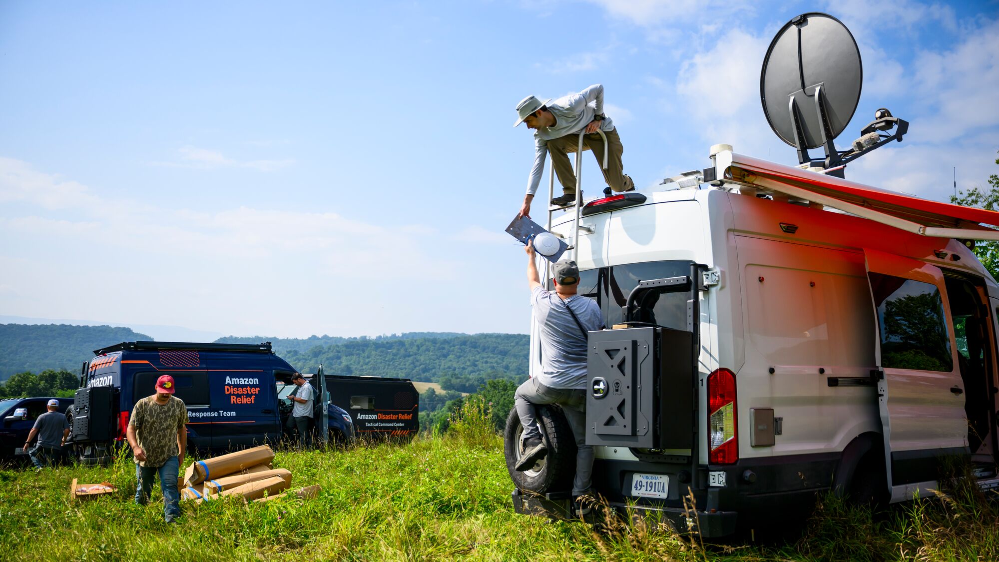Amazon Disaster relief workers setting up satellite communications in rural area
