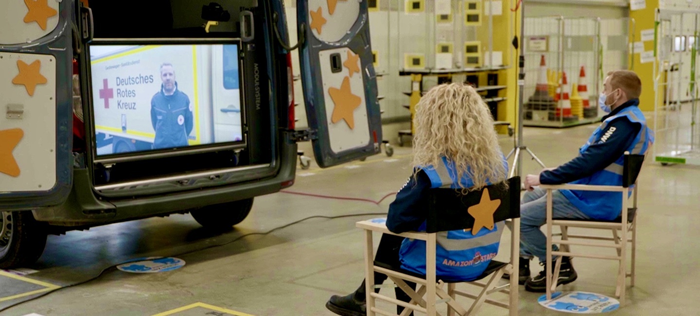 Atefe und Thomas von hinten, in einem Stuhl sitzend, der mit einem Amazon Star versehen ist.
