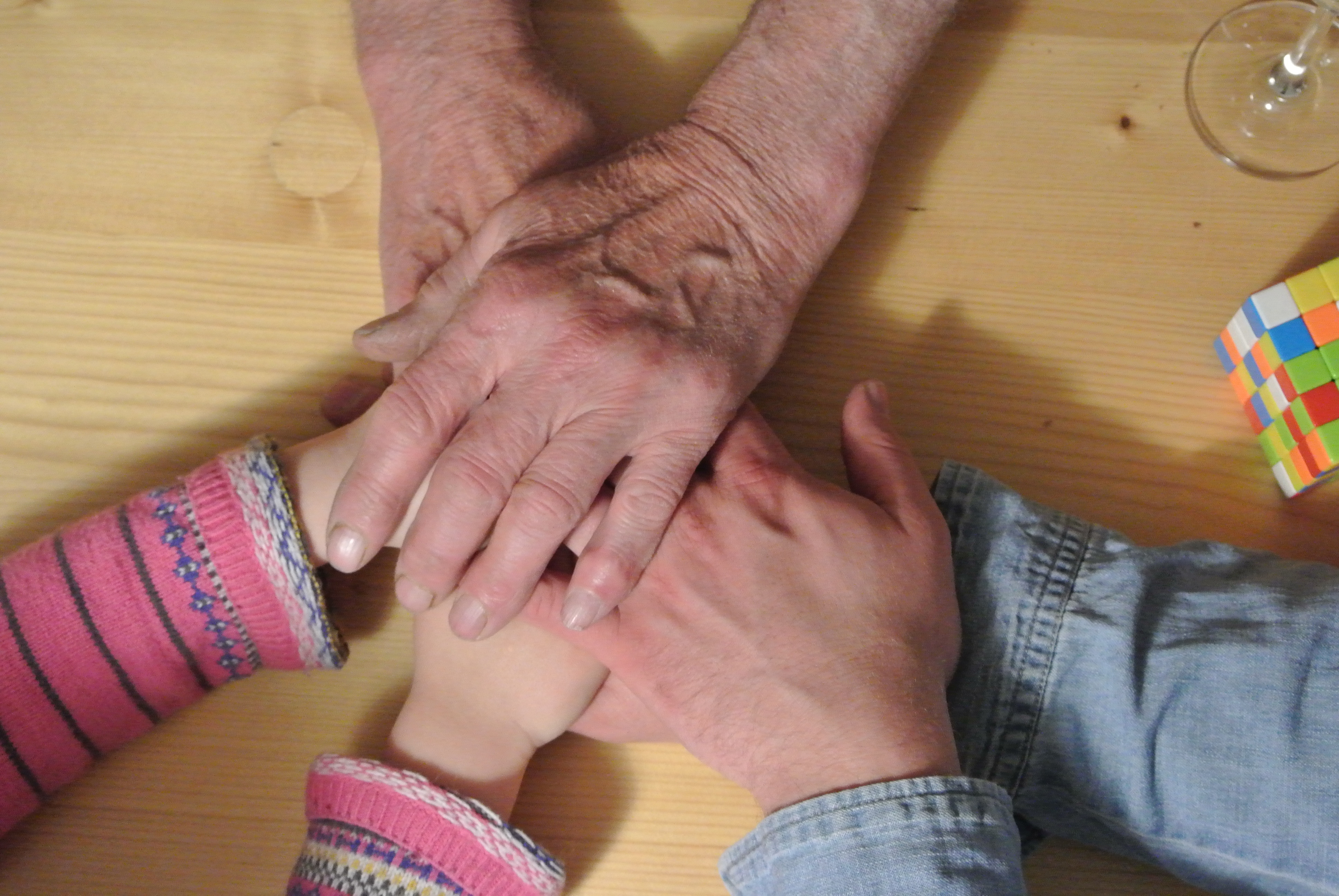 Eine Familie legt ihre Hände aufeinander 