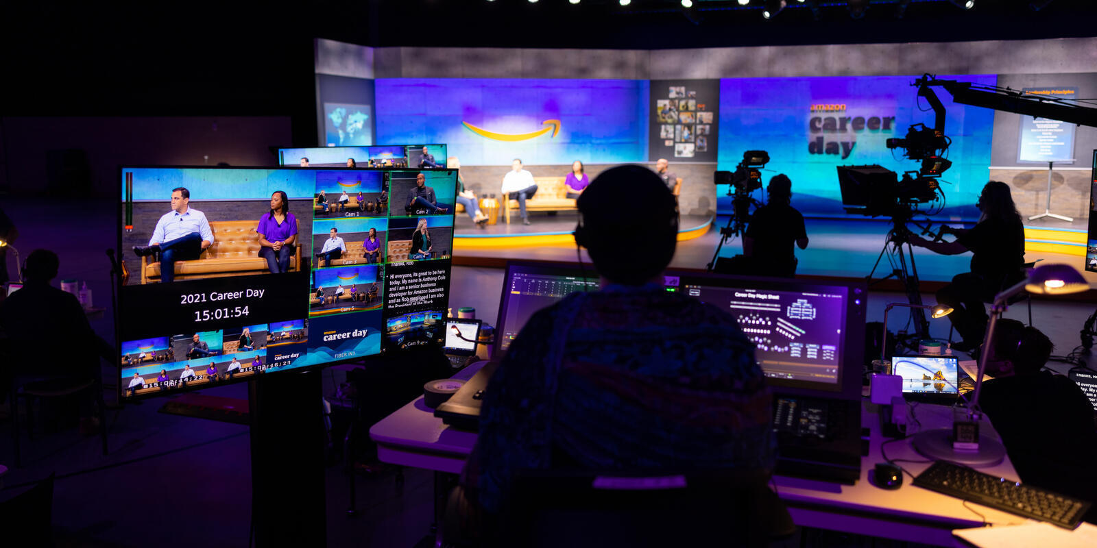 A person sitting behind a series of monitors works on Amazon Career day