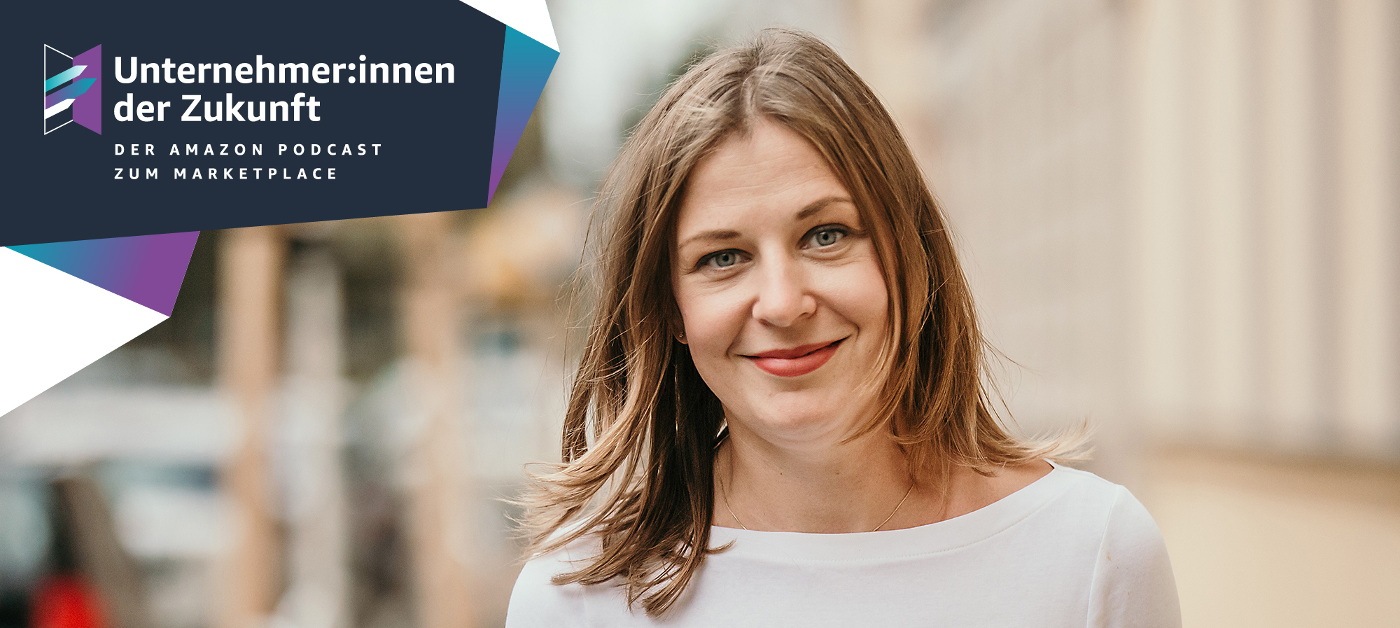 Eine Frau mit braunen Haaren und einem weißen Langarmshirt lächelt in die Kamera. Neben ihr stehen die Worte "Unternehmer:innen der Zukunft"