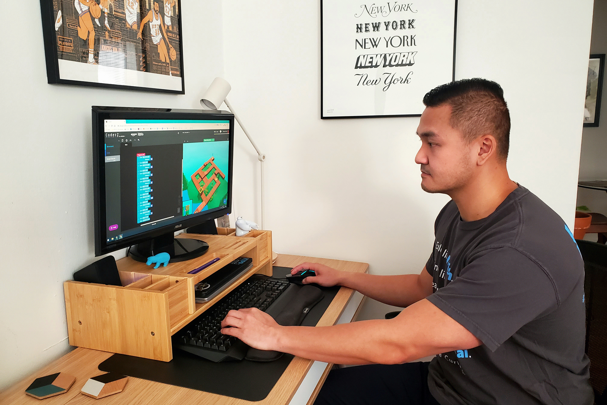 A man sits at a desk and works on a computer.