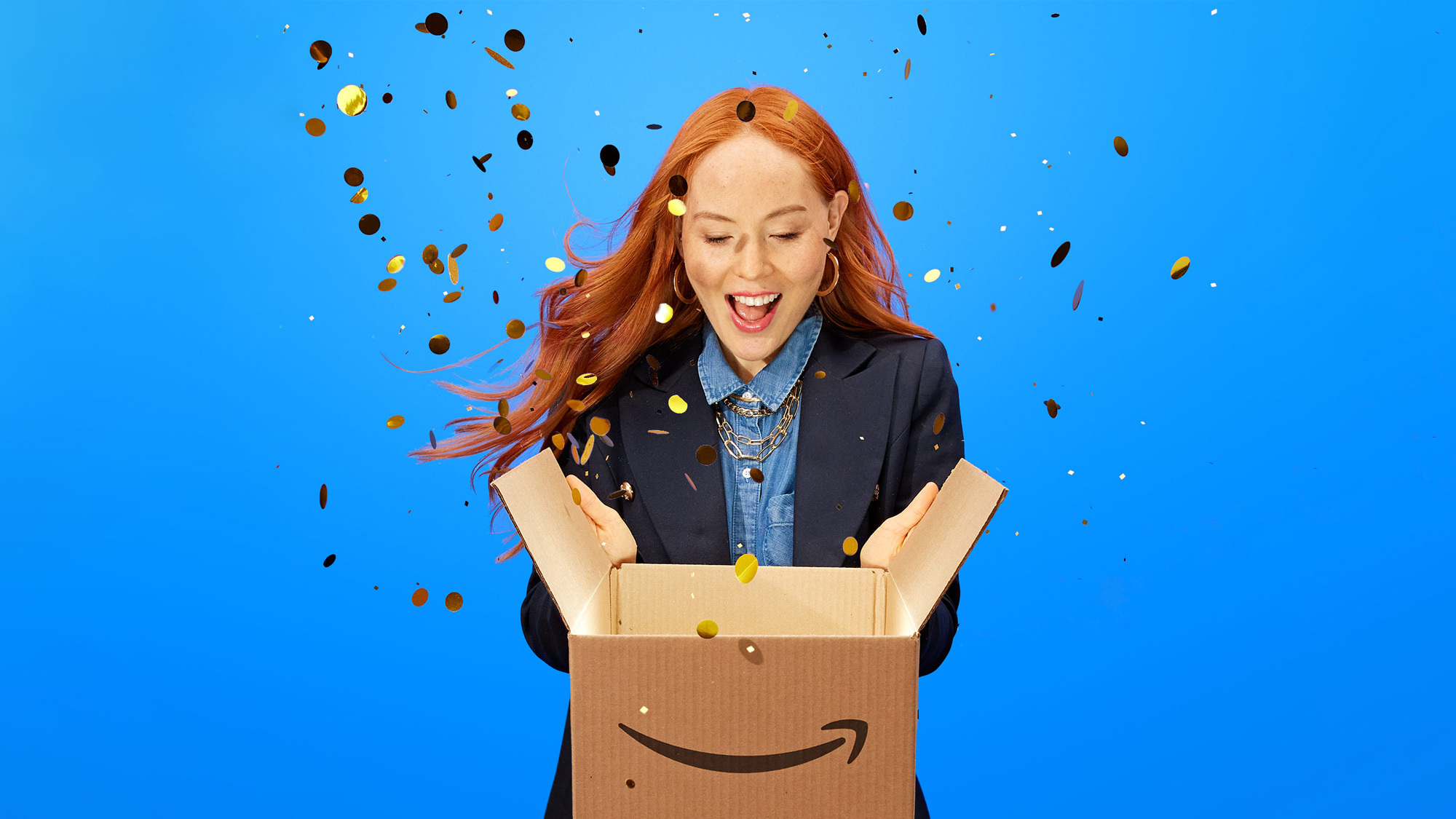 An image of a girl opening an Amazon box and gold confetti is flying out of it