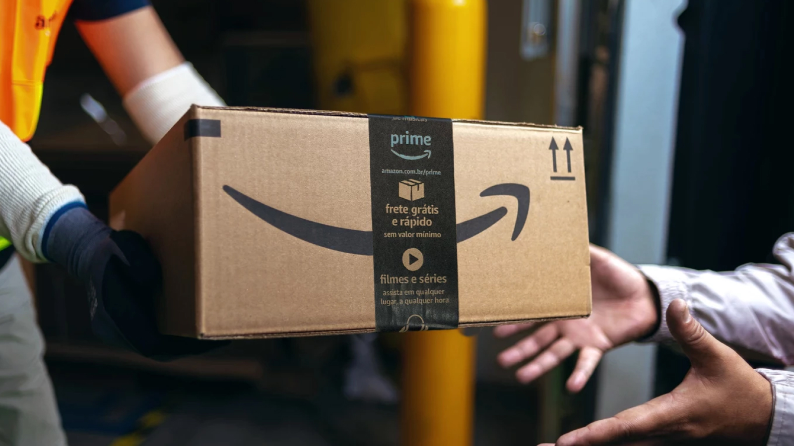 amazon box being passed between two sets of hands