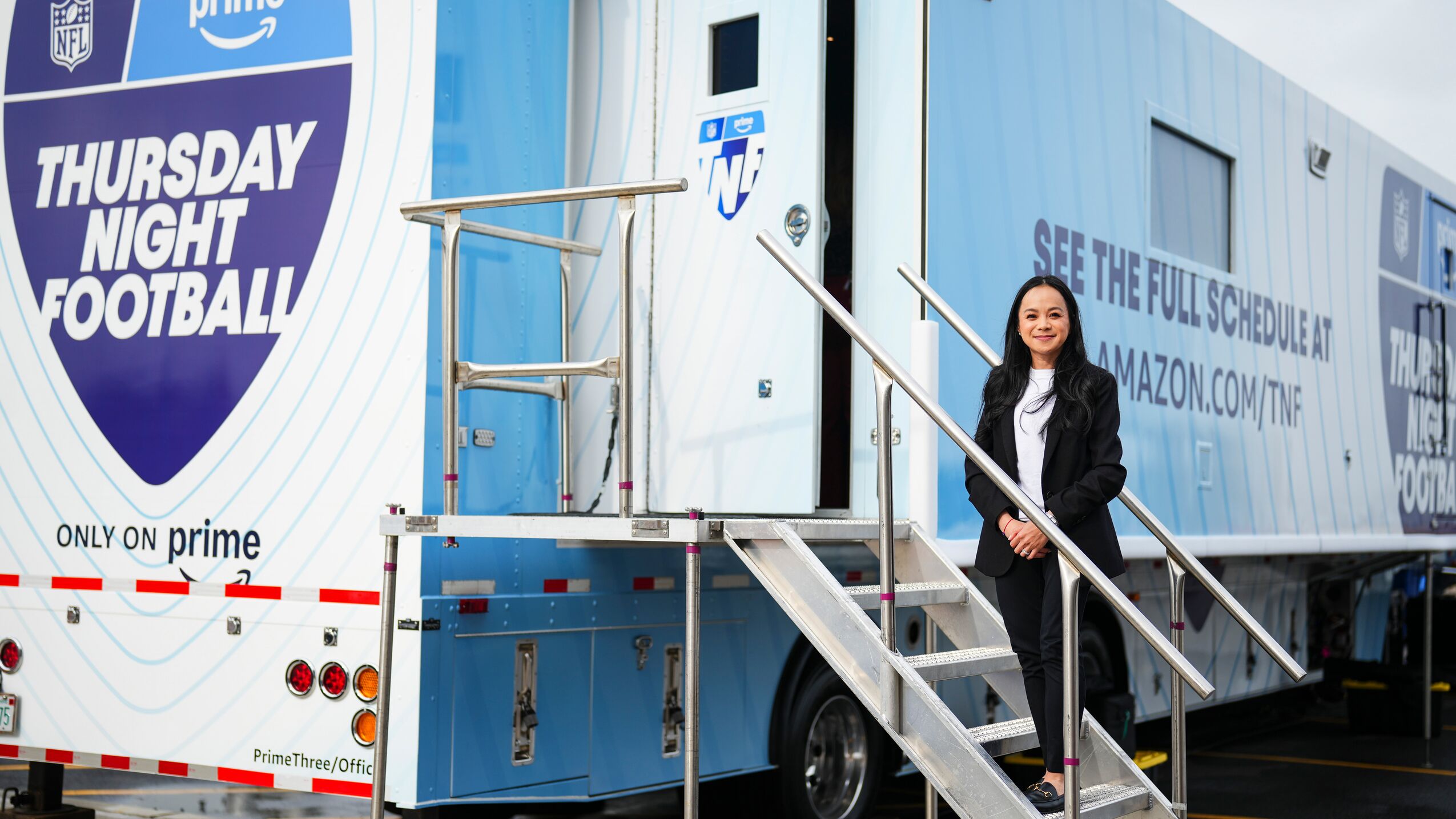 Woman in front of a 'Thursday Night Football' production truck