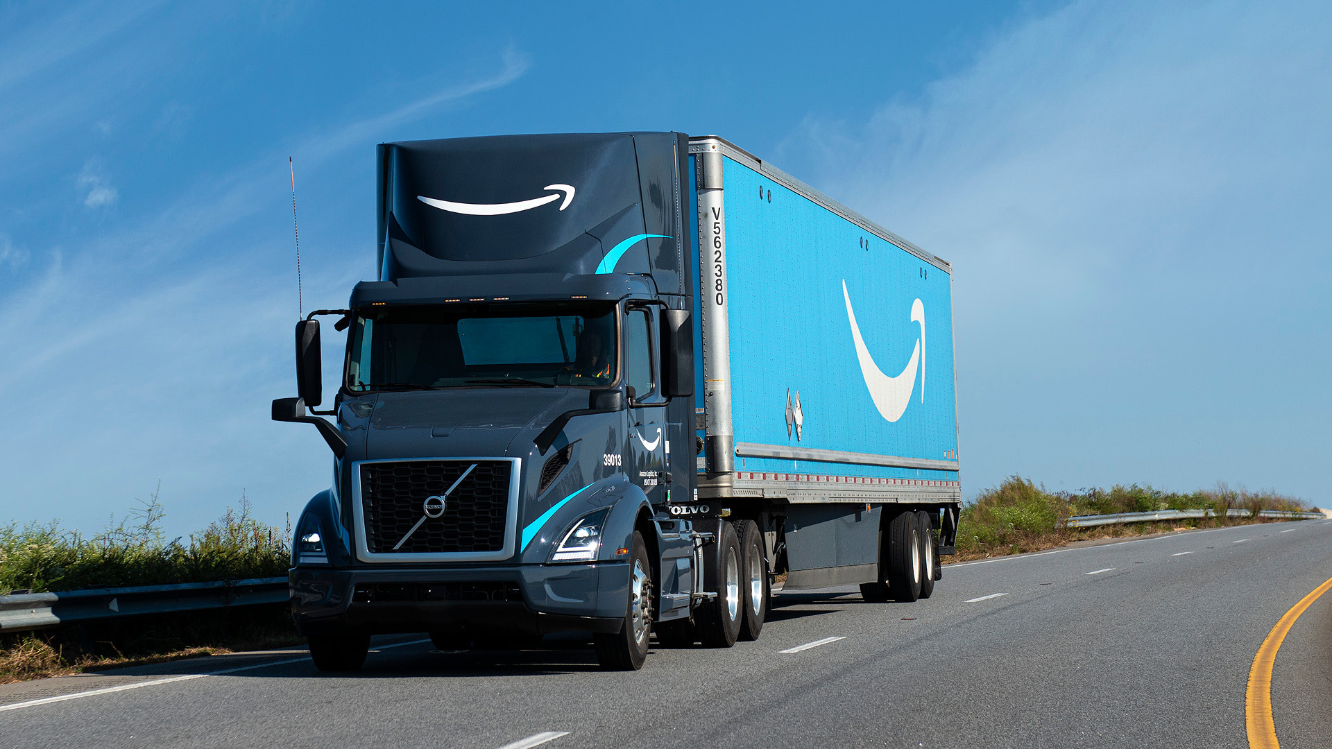 A photo of an Amazon delivery truck driving on a rural road.