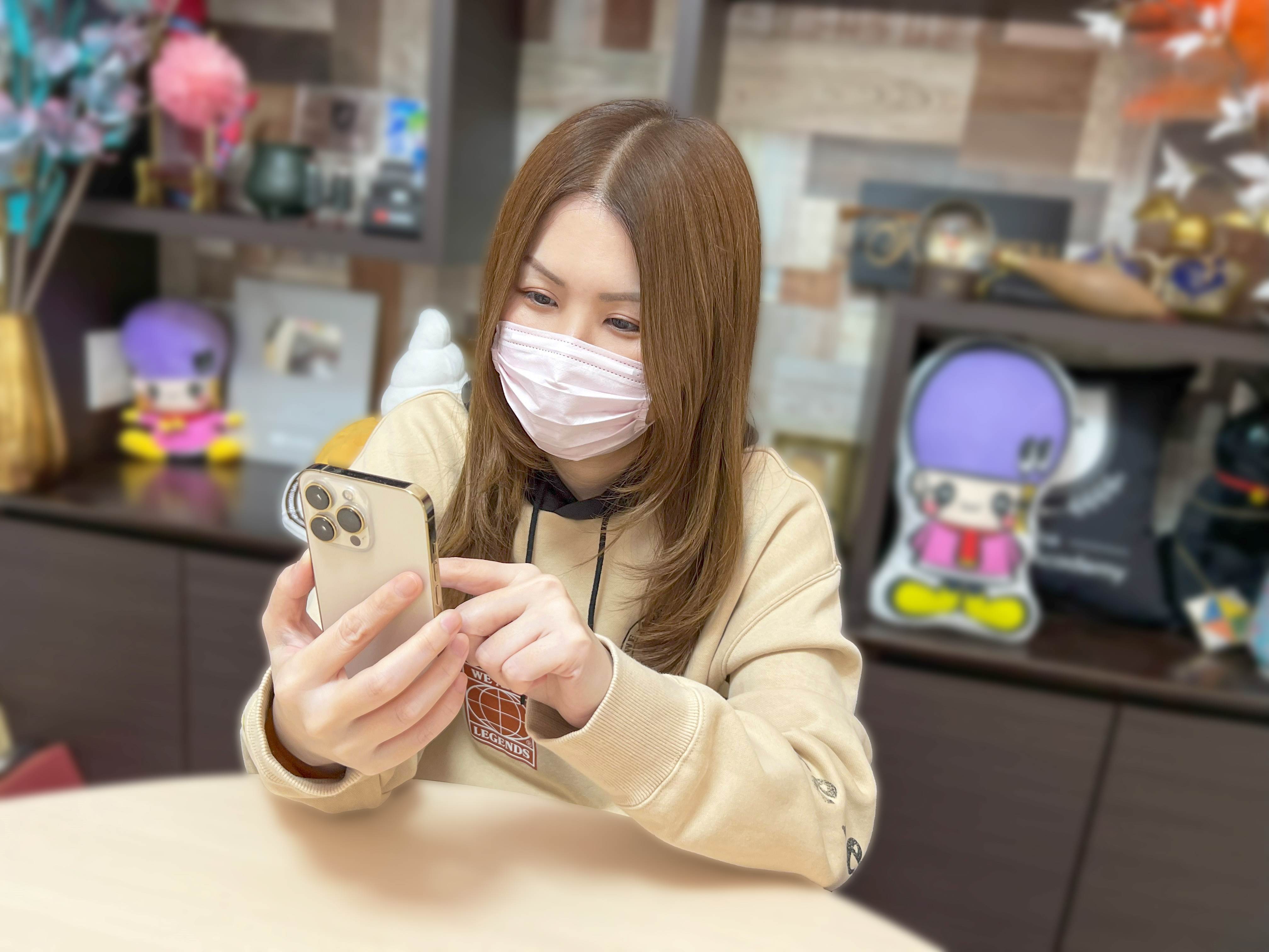 茶色の髪の女性が携帯を指しながらニヤニヤしている。「アジーンTVさん」