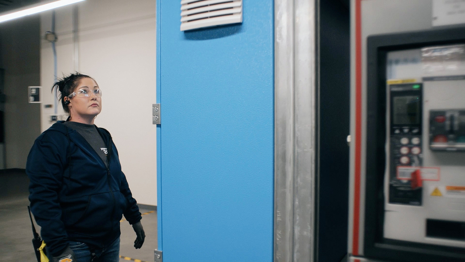 A photo of Tasha Engum inspecting equipment in an AWS data center.