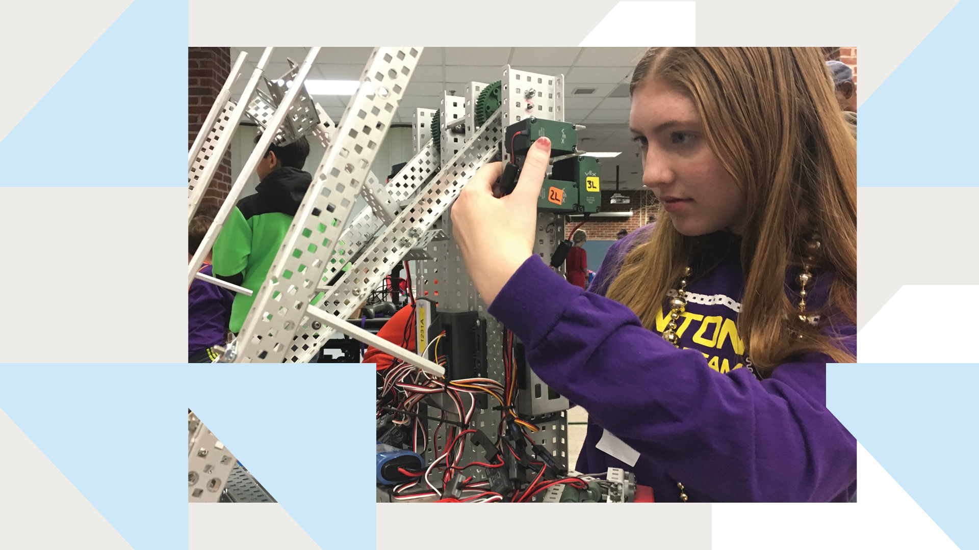 An image of a young woman working on a robotic device. 