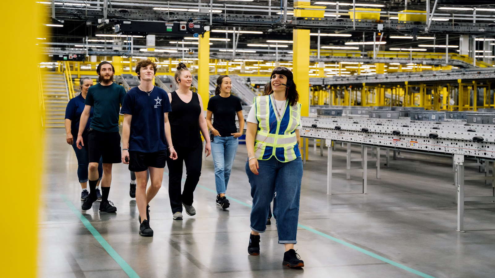 Amazon employees giving a tour of a fulfillment center.