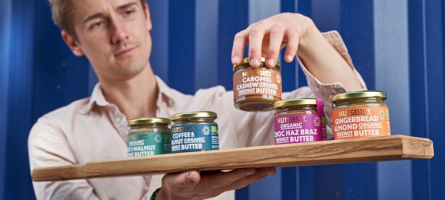 Nutcessity Founder with products on wooden chopping board